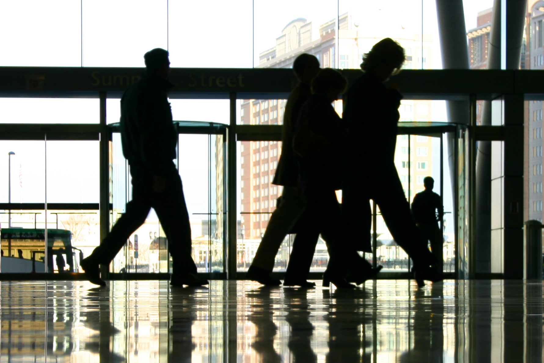 silhouettes of four people in an office lobby