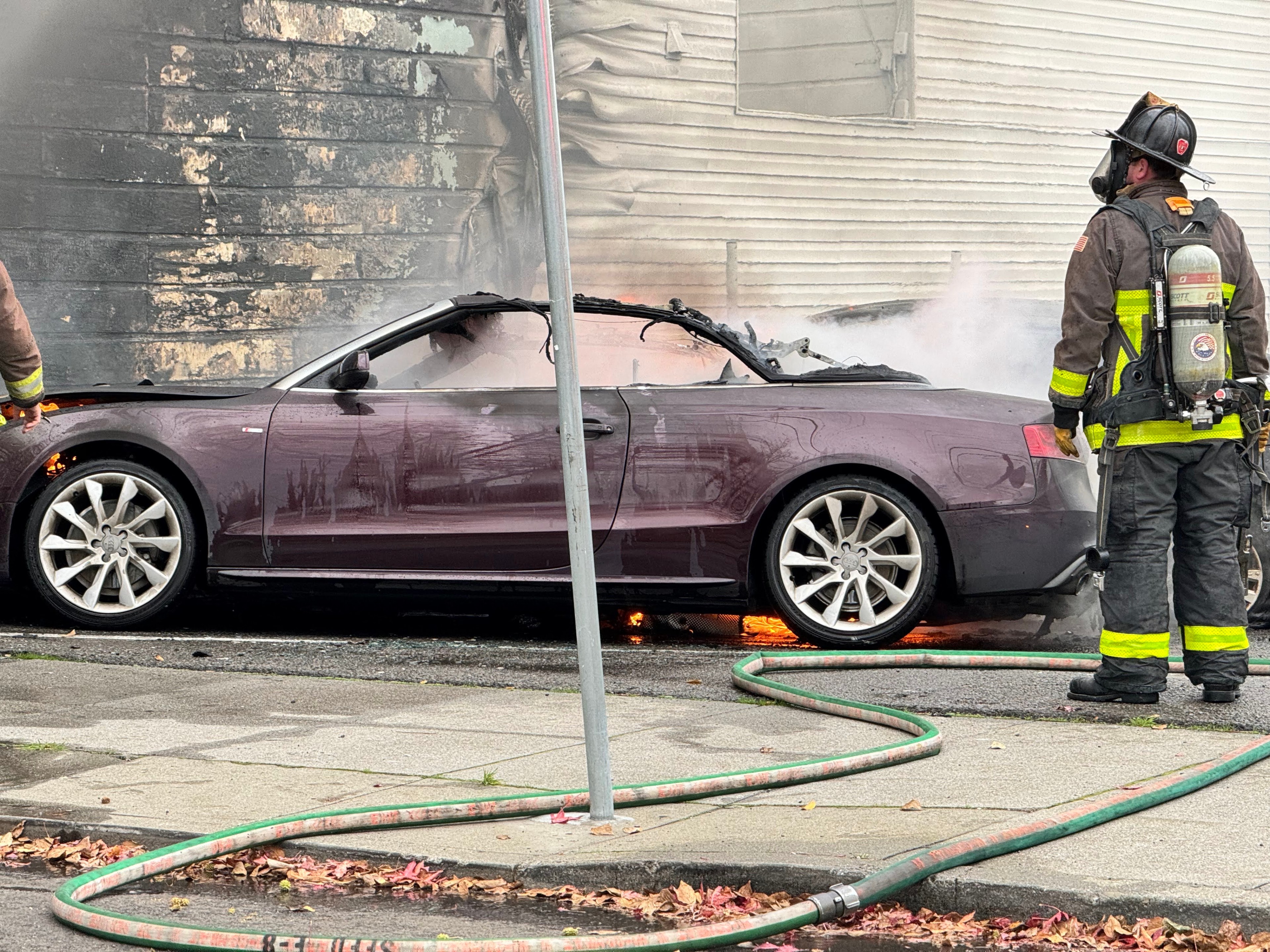 San Francisco firefighters extinguish two cars which were set on fire at a parking lot off Boardman Place on Jan. 2, 2024.