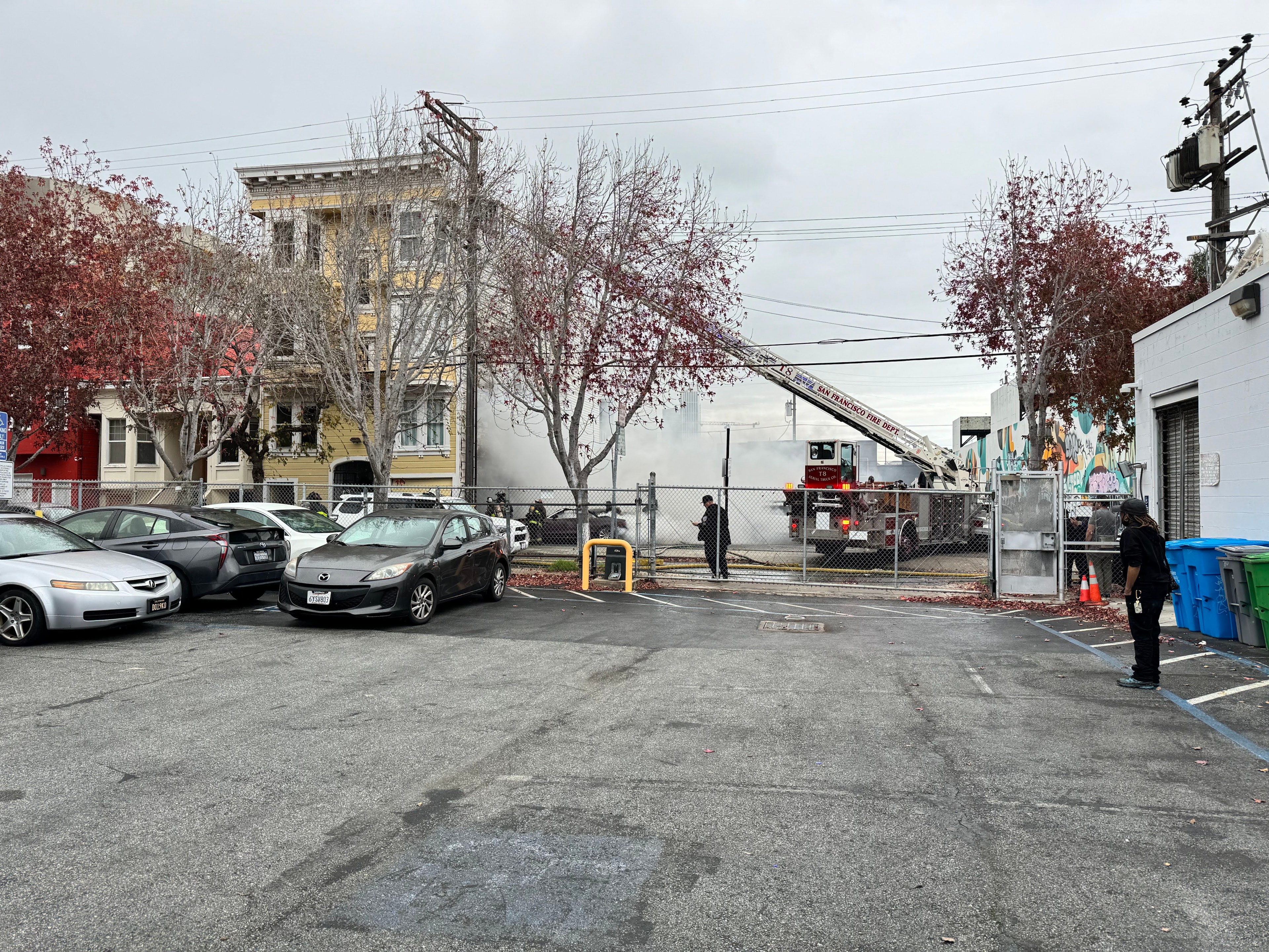 San Francisco firefighters extinguish a fire at a parking lot off Boardman Place on Jan. 2, 2024. Police are searching for a suspect in the incident.