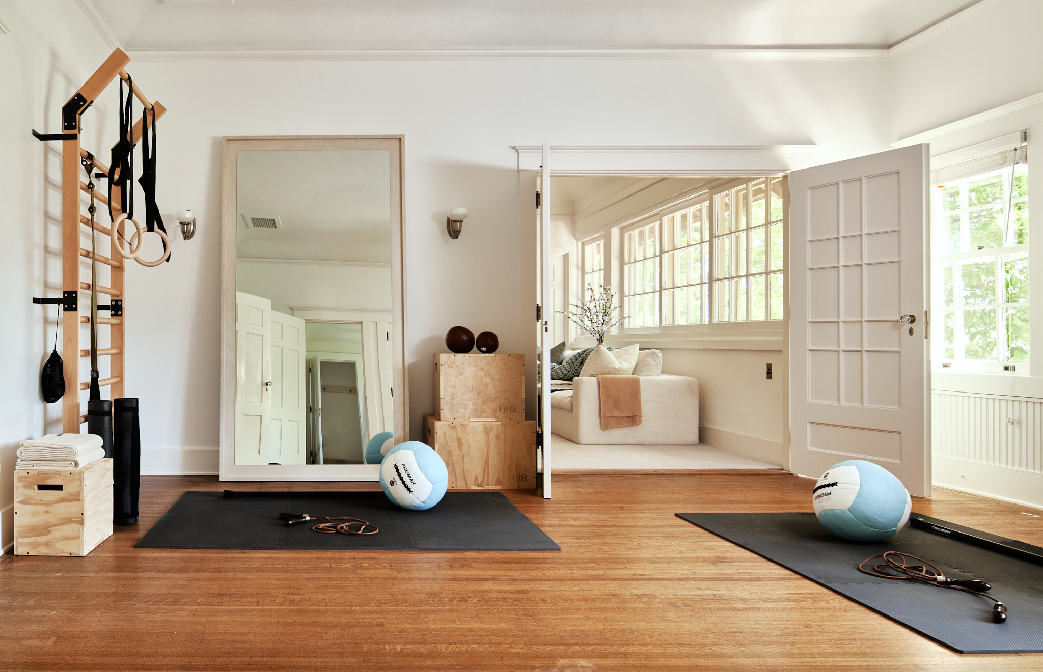 A workingout room with a medicine ball, yoga mate, and mirror. 