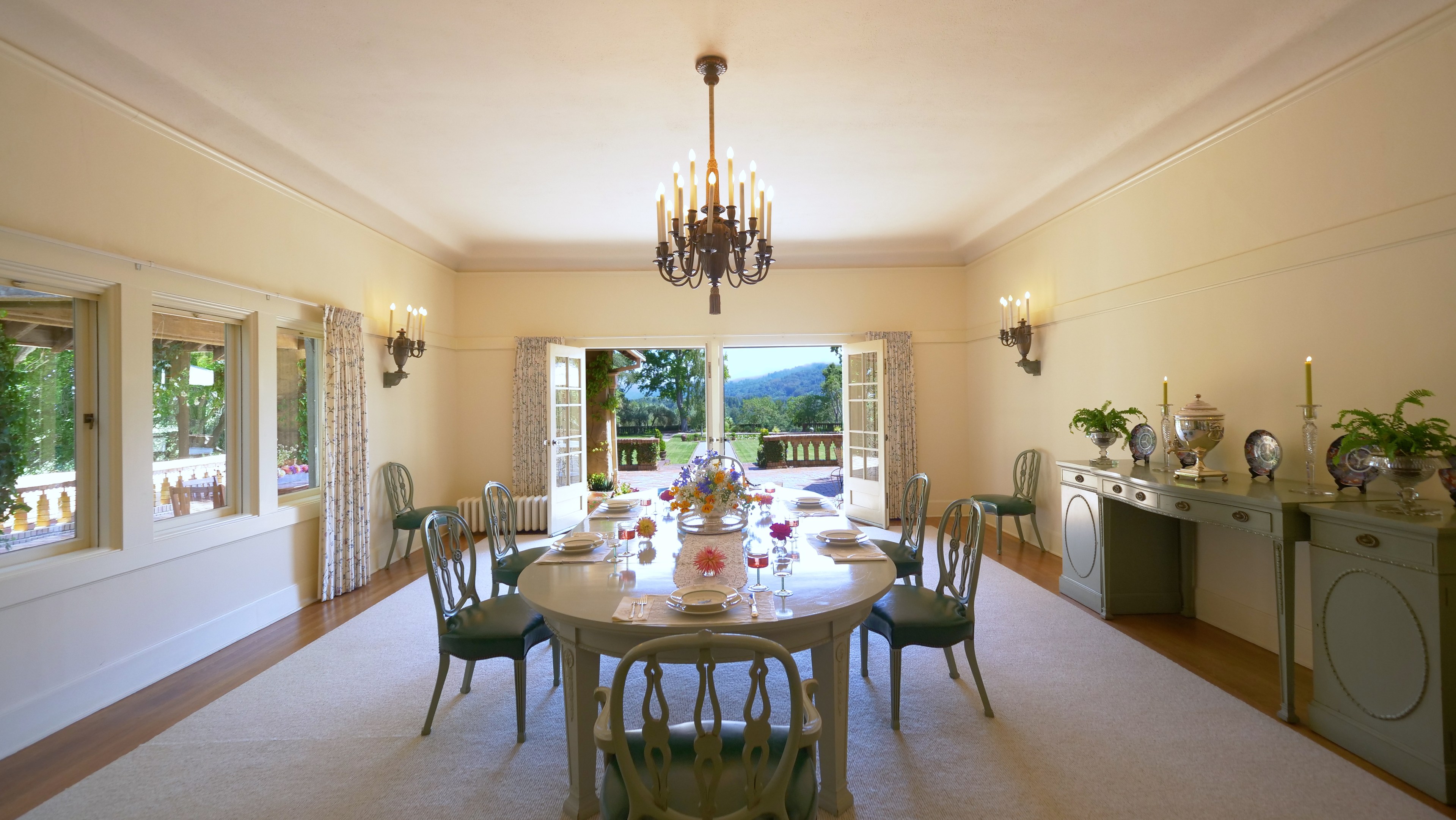 A dining room with doors leading to a yard. 
