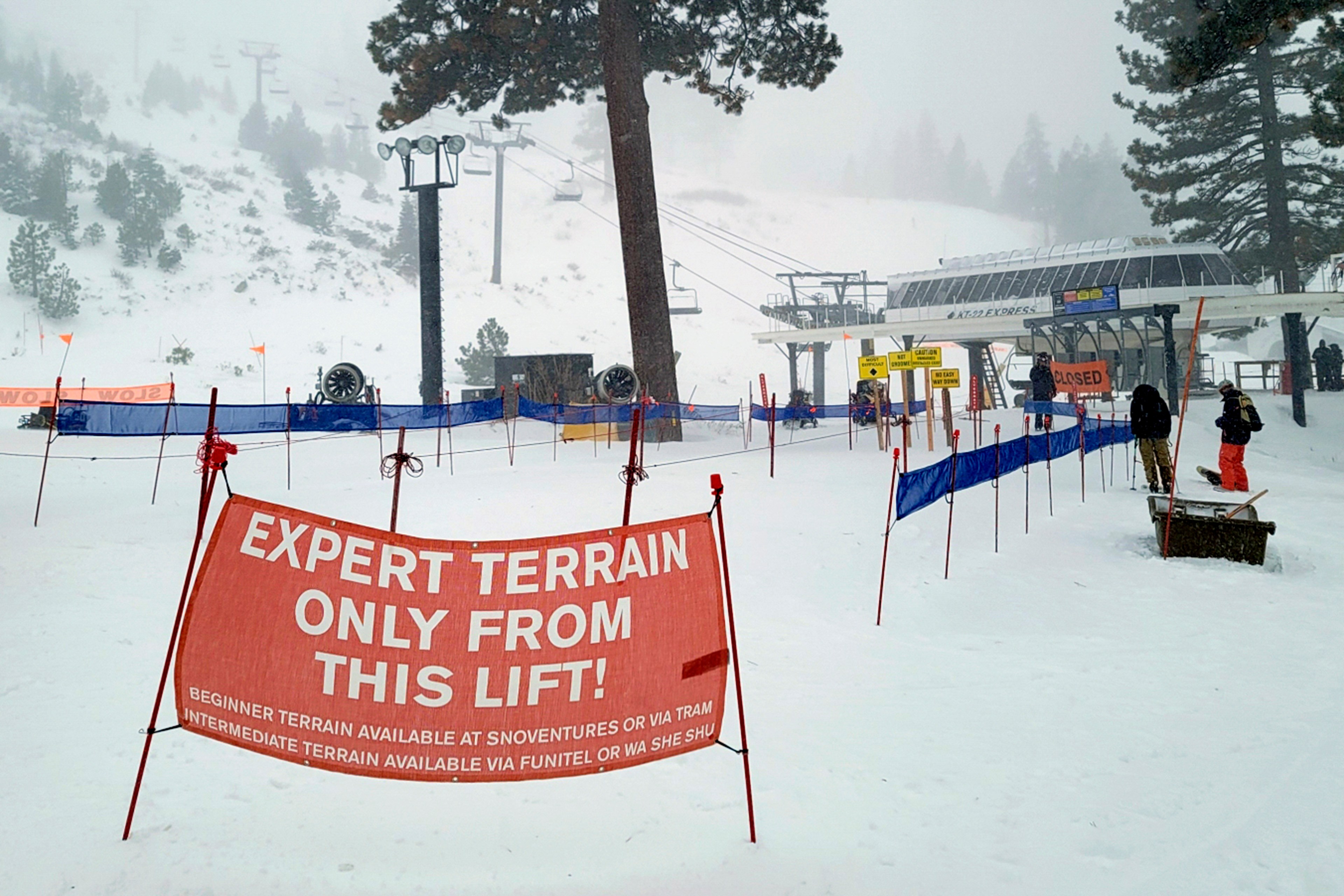 A red sign warns of expert terrain outside a ski lift