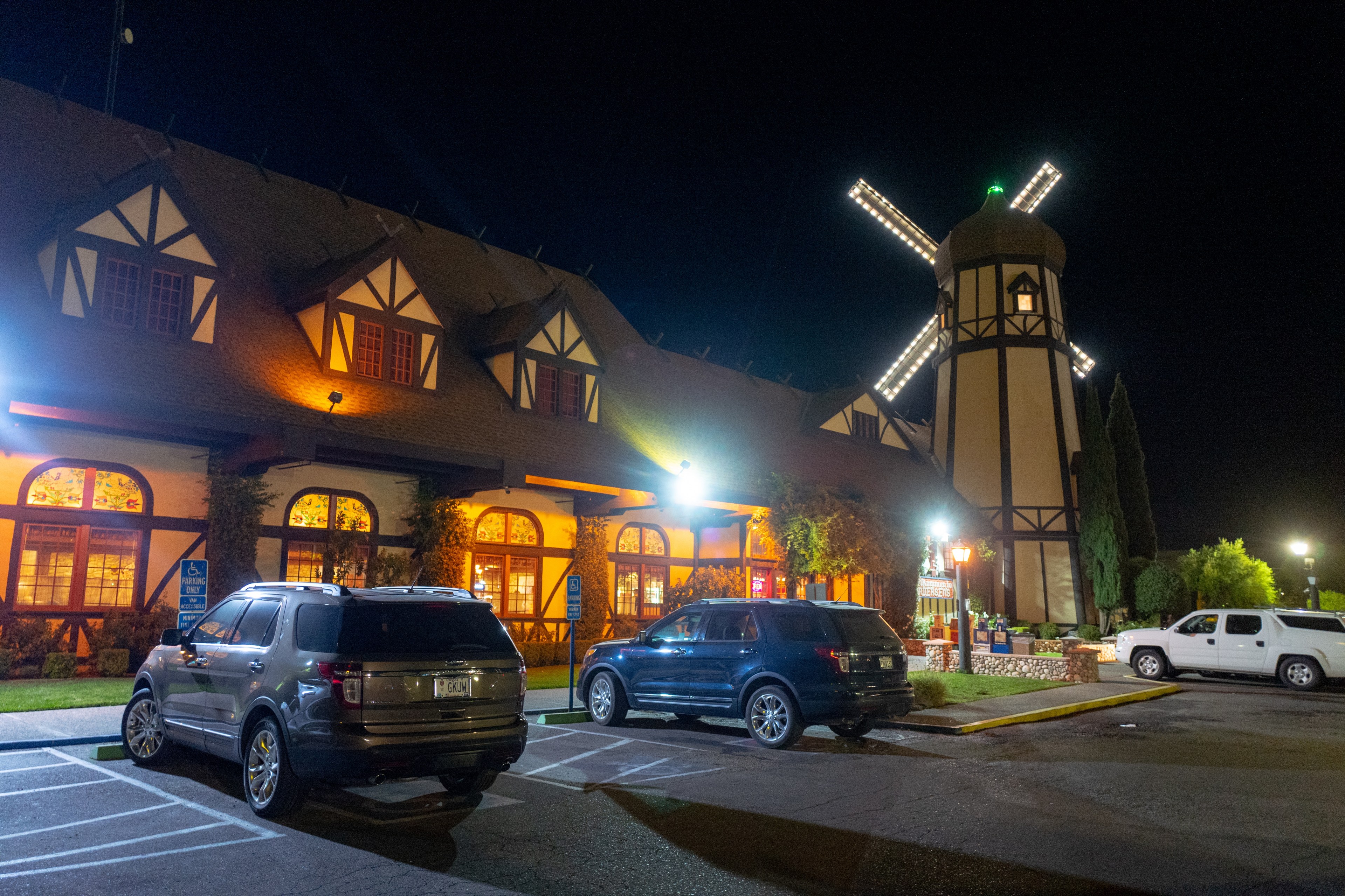 a restaurant parking lot by night, with a windmill