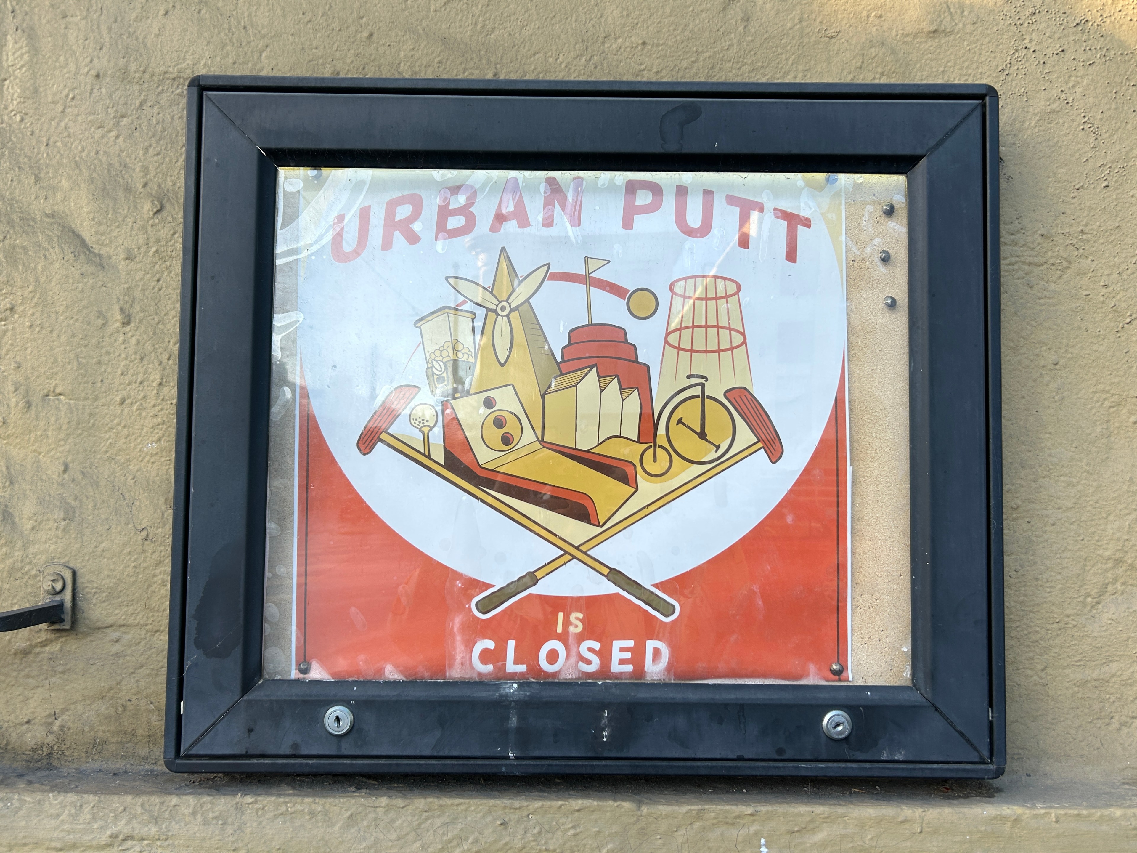 An exterior sign by day stating that an indoor mini golf course has closed.