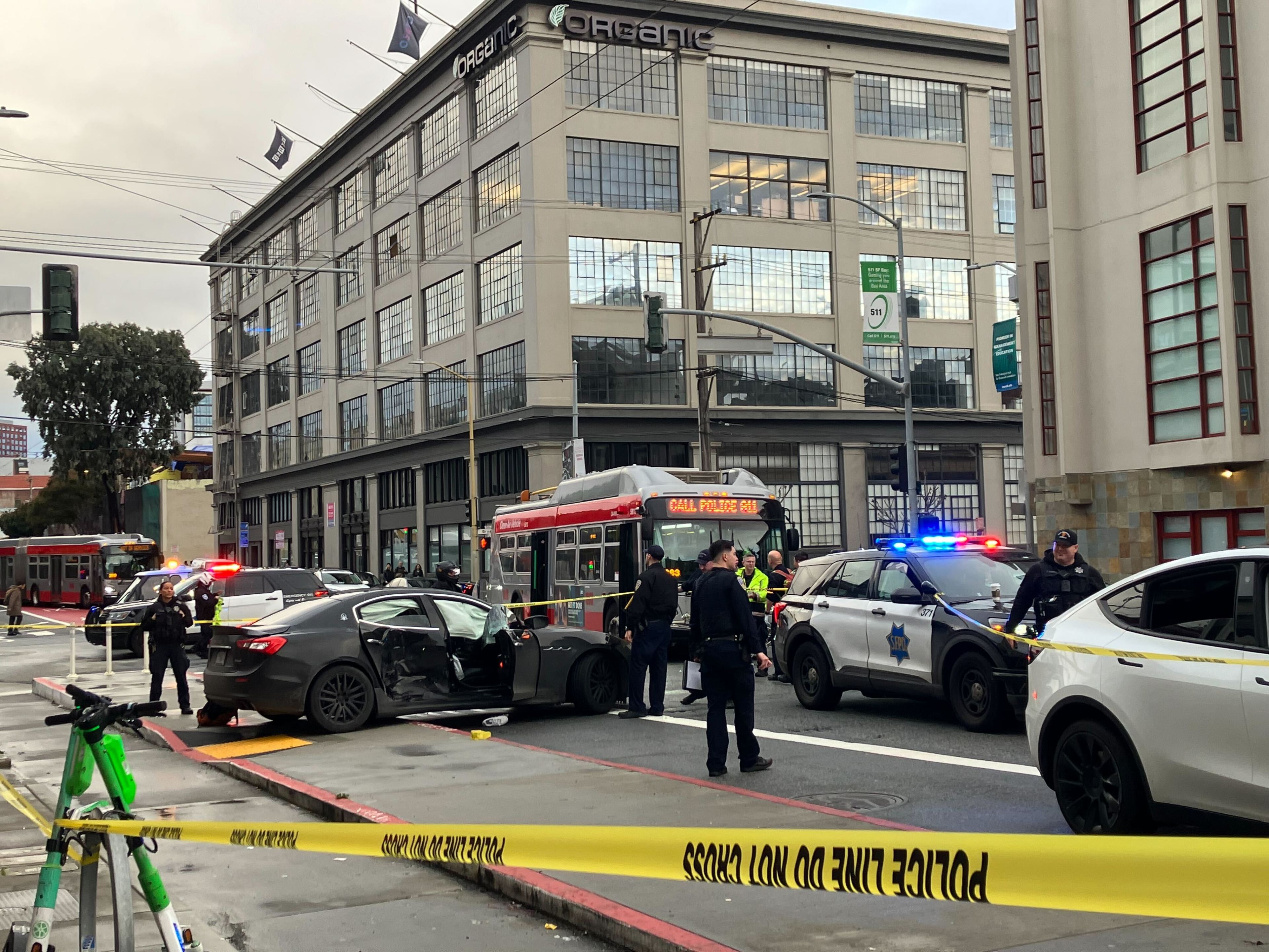 San Francisco police officers investigate a collision between a Maserati and a Muni bus that happened during a pursuit that ended near 3rd and Bryant streets on Wednesday, Jan. 24, 2024.
