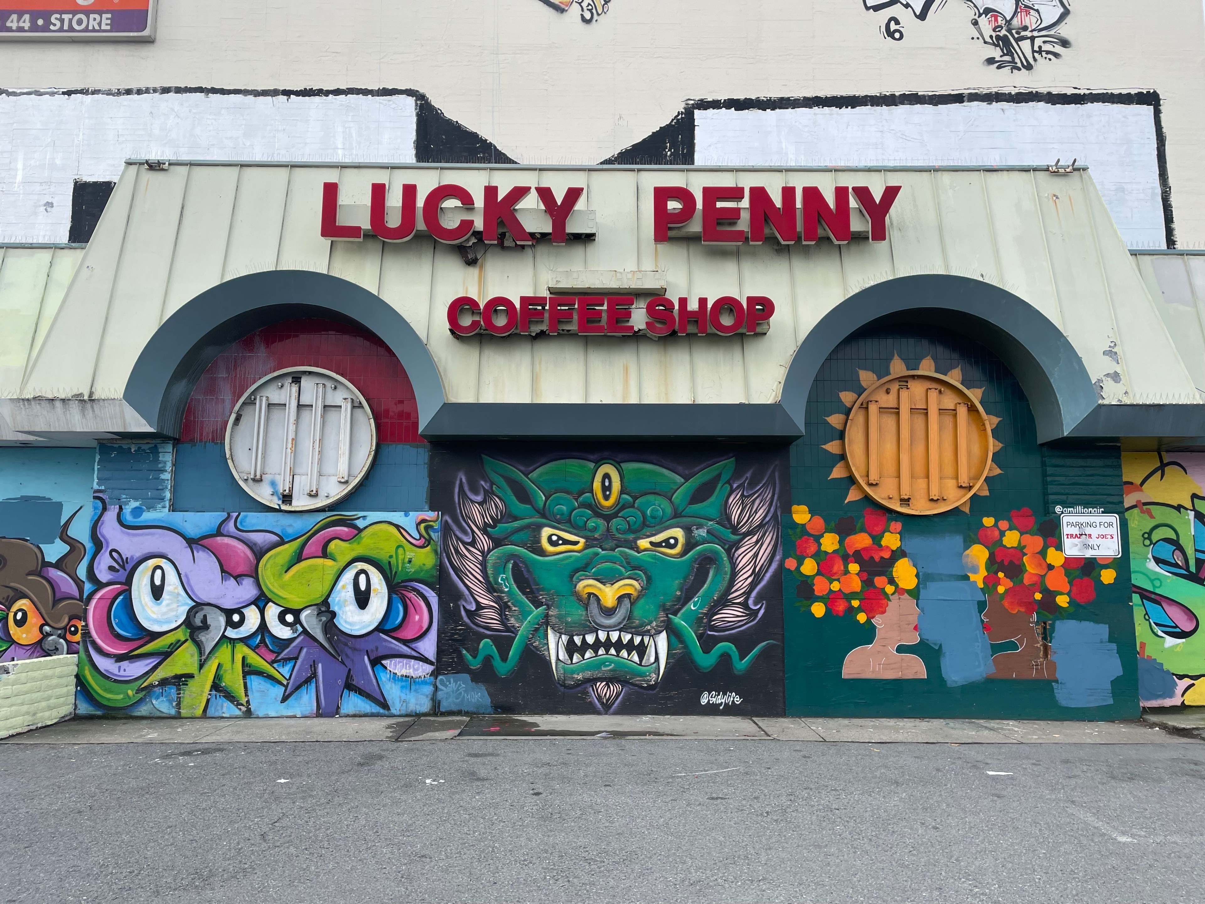 A boarded-up diner is covered with murals and graffiti.