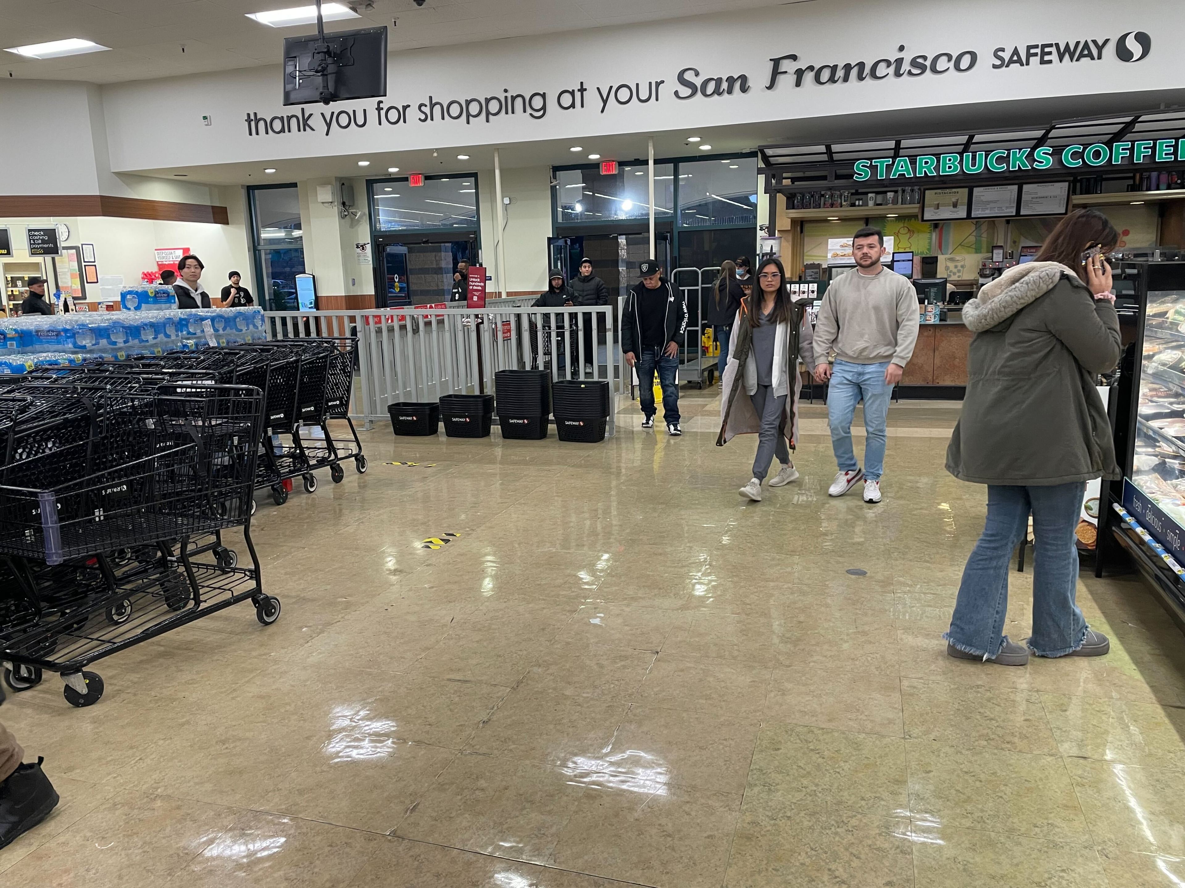 Customers walk inside a grocery store.
