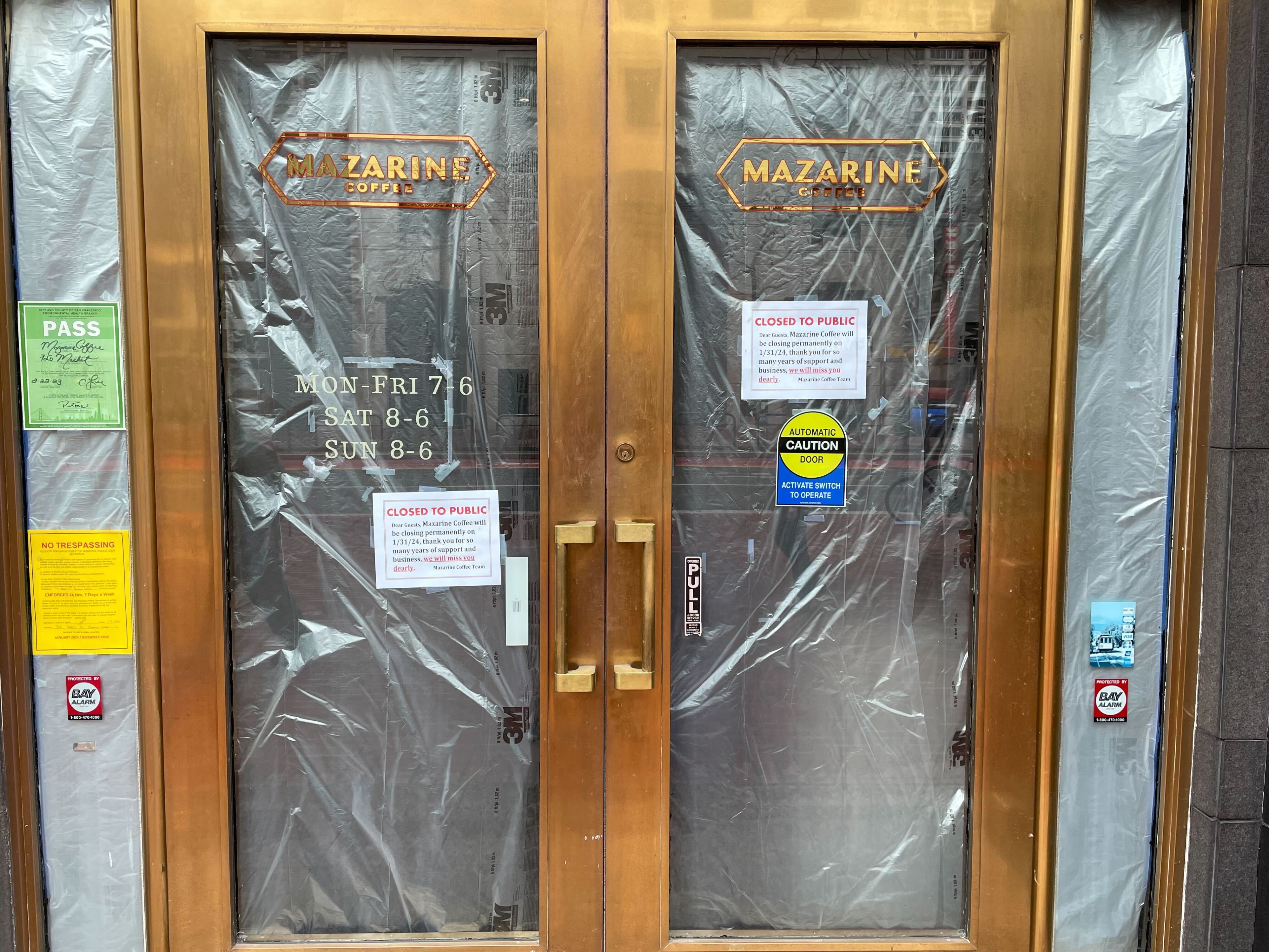 A cafe door is closed with a sign announcing it's going out of business.