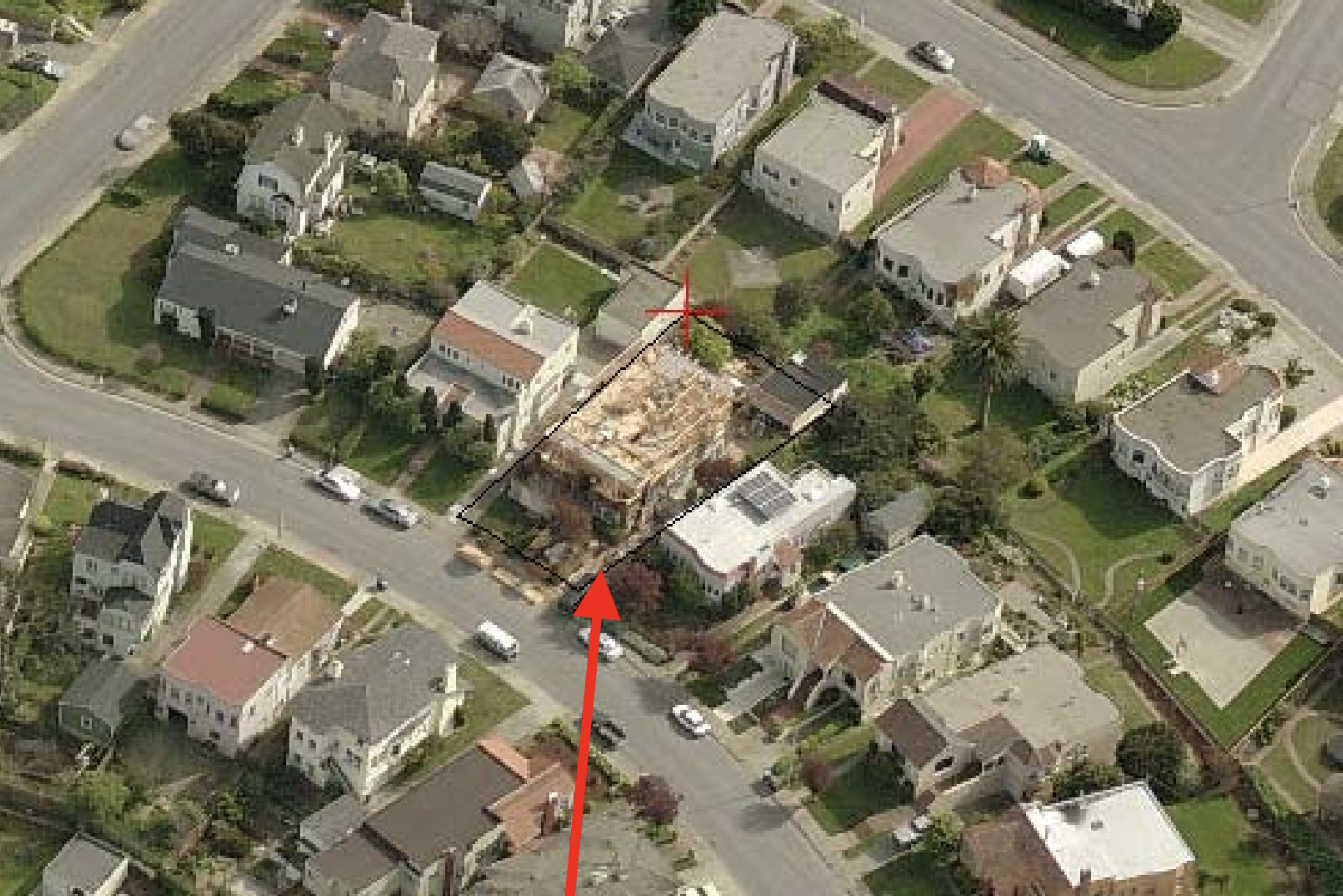 Aerial view of a neighborhood, marked arrow pointing to a house under construction among intact homes.