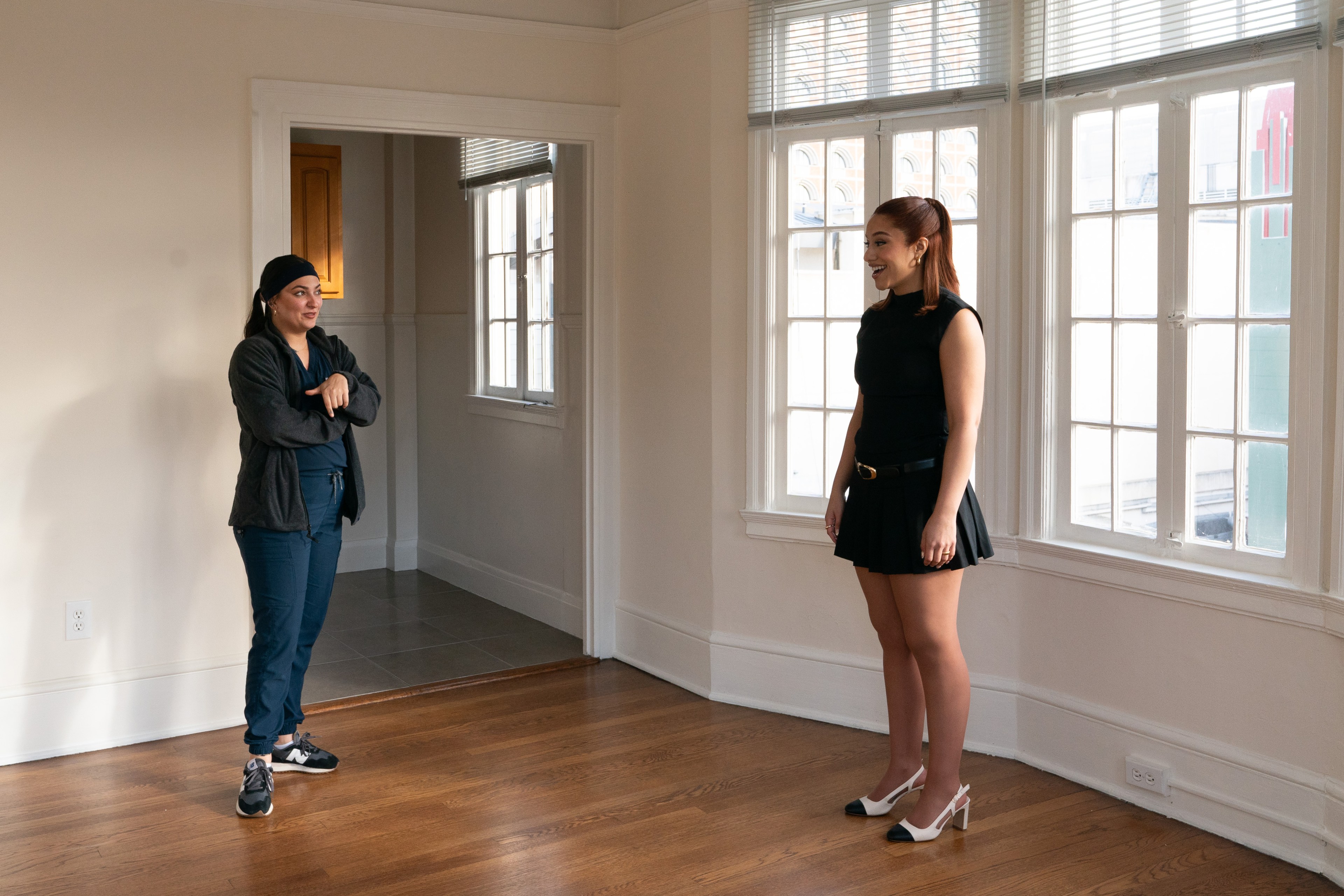 two women speak in an apartment