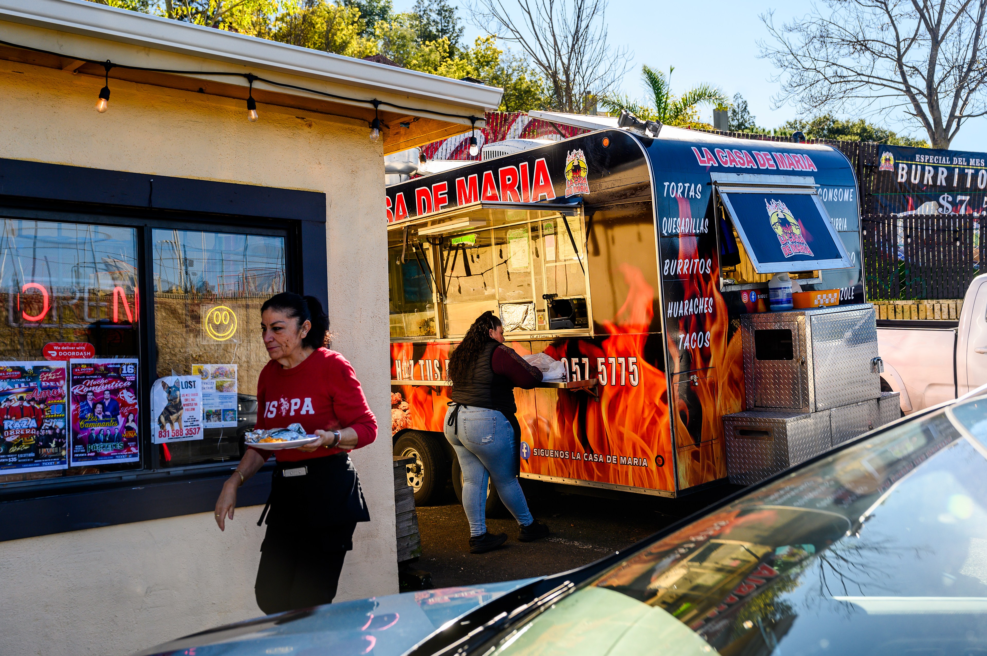 Waitresses carry food at La Casa de Maria, a restaurant that advertises with Gregorio Ramon, on Saturday, Feb. 10, 2024, in Oakland.