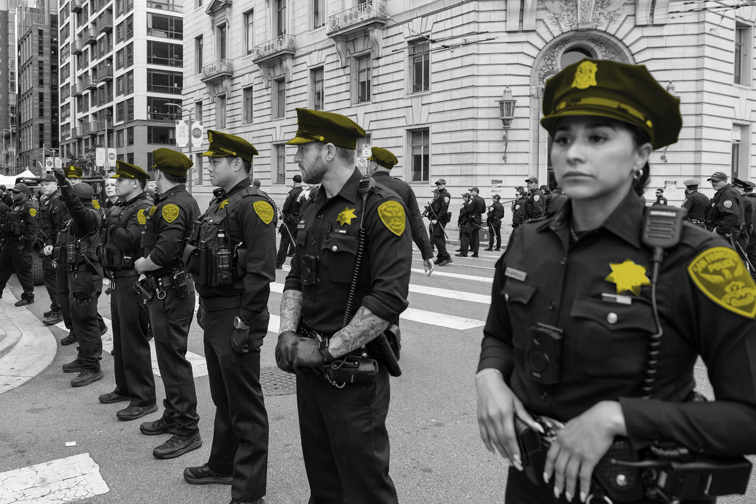 A group of police officers in uniforms stands lined up, badges prominent; image is monochrome with the badges highlighted in yellow.
