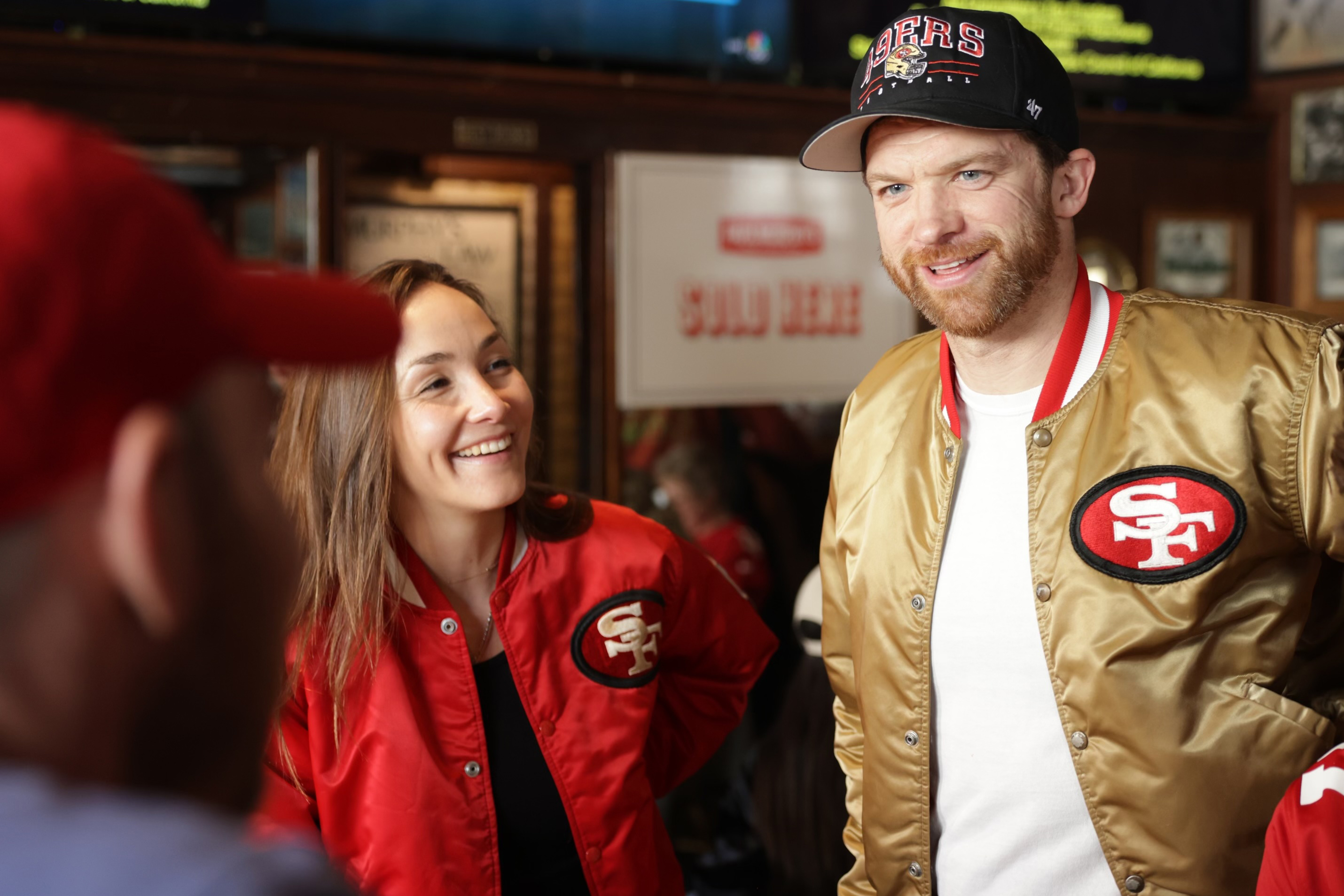 Woman in red starter jacket and man in gold starter jacket