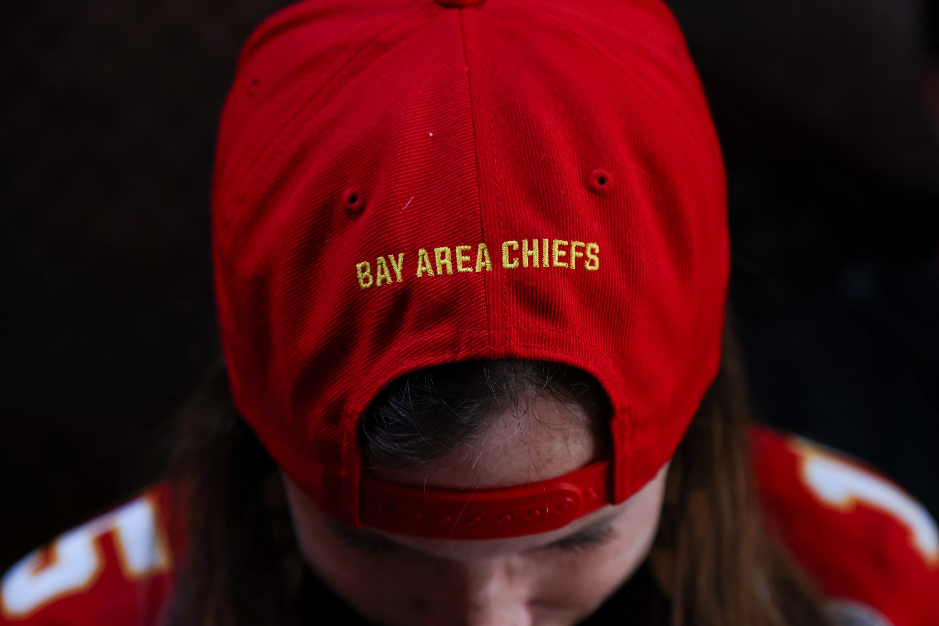 A fan shows off red baseball cap that says Bay Area Chiefs