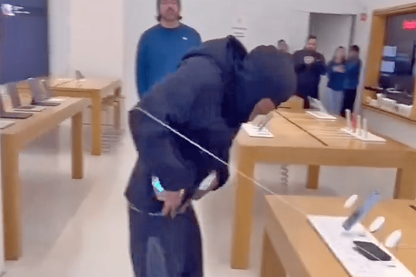 A man steals iPhones from an Apple store.