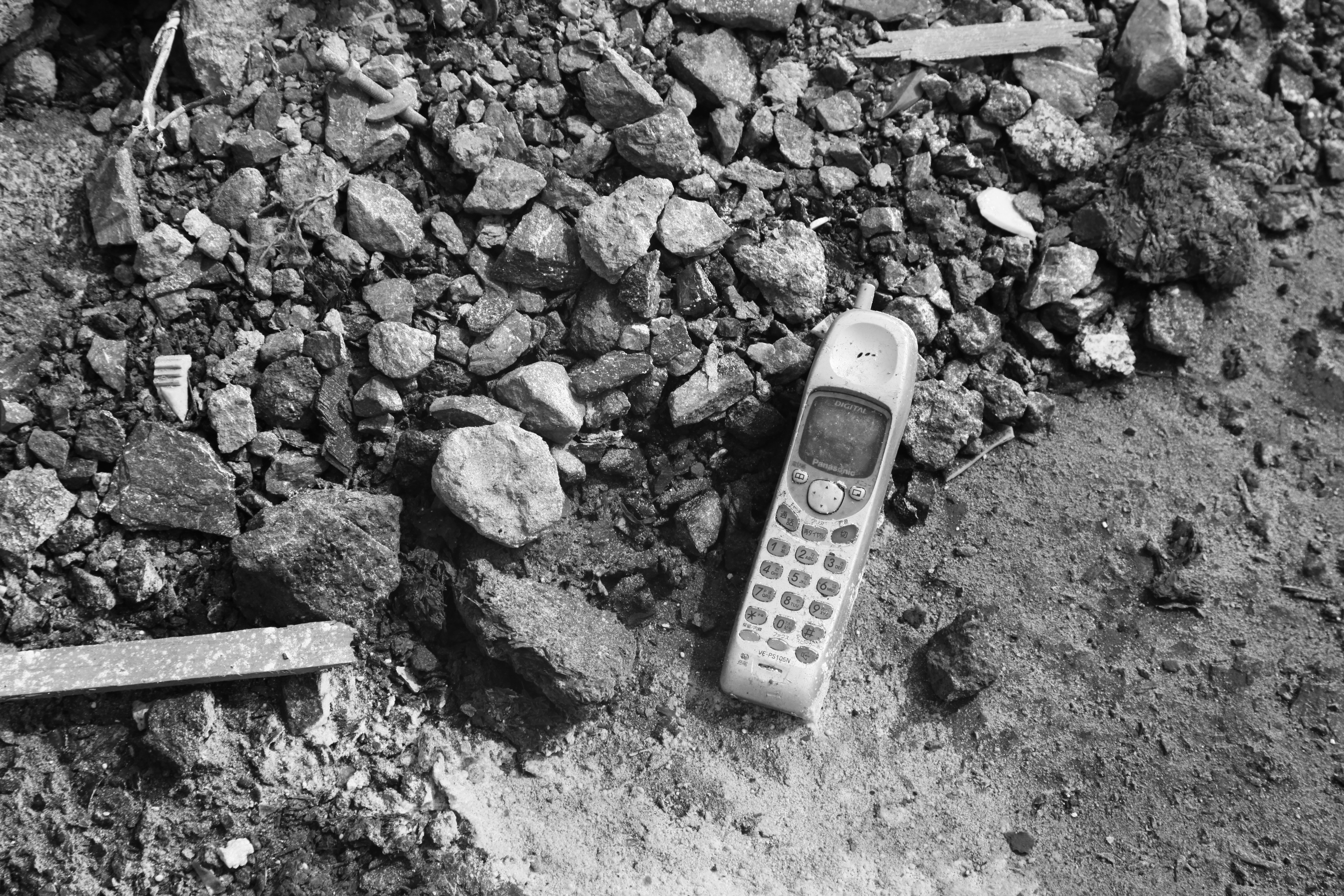 An old telephone lies amidst rubble and debris.