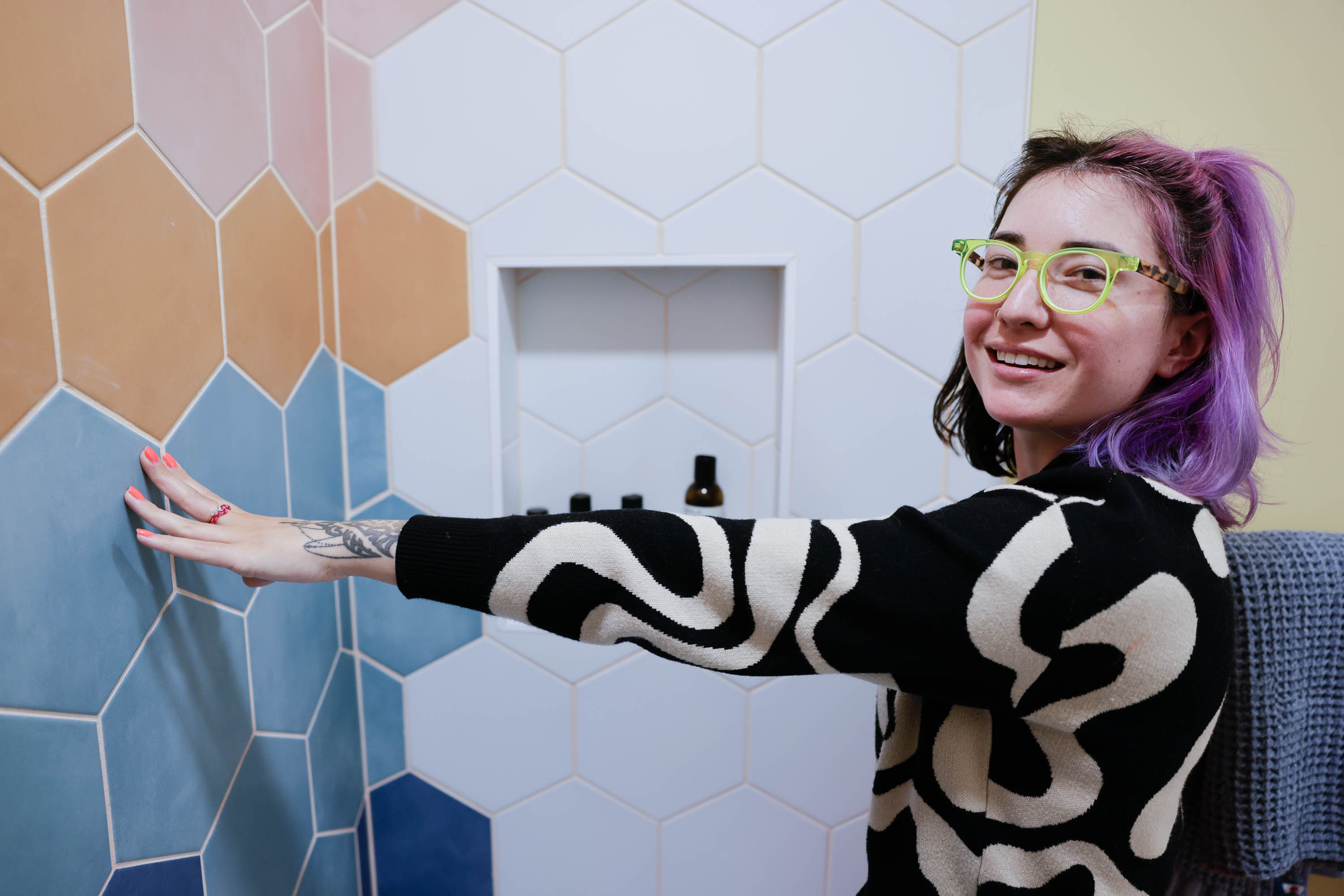 Tay &quot;BeepBoop&quot; Nakamoto touches a rainbow tile bathroom wall she had installed at her clients' Instagram-famous house, the Floral House.