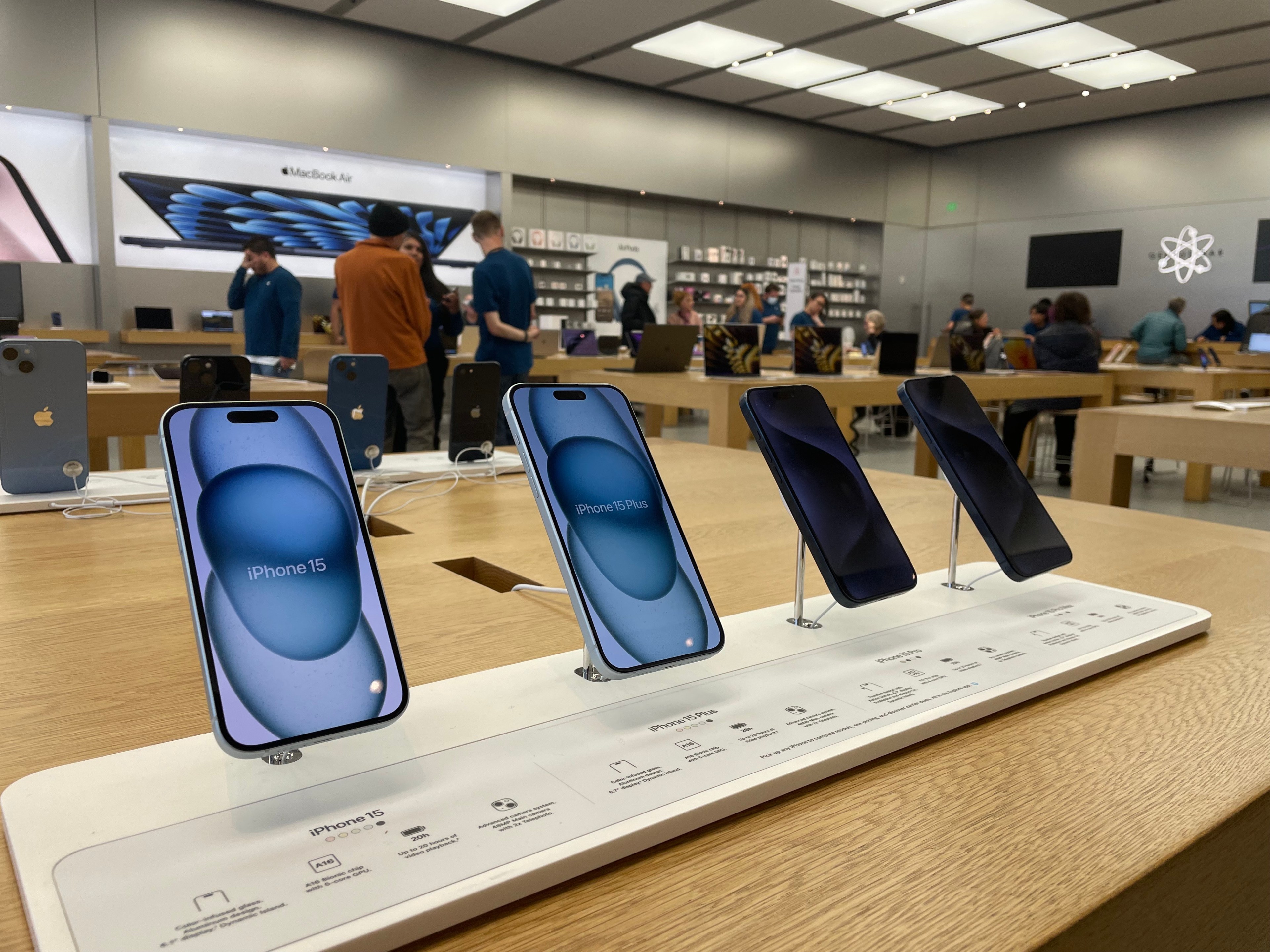 iPhones are displayed inside an Apple Store.
