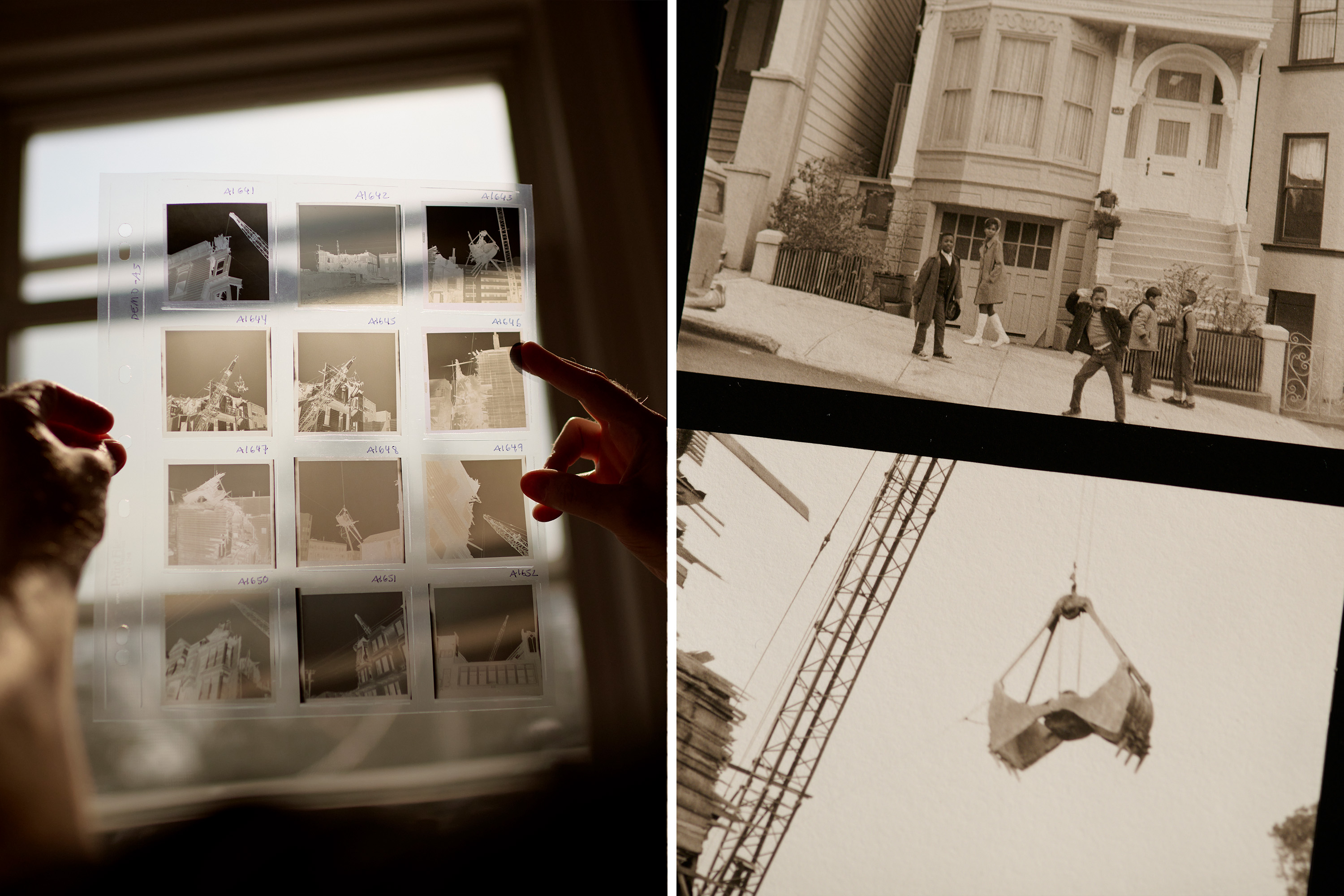 A person examines film negatives in light; a vintage photo of people by a house; a construction crane lifting debris.