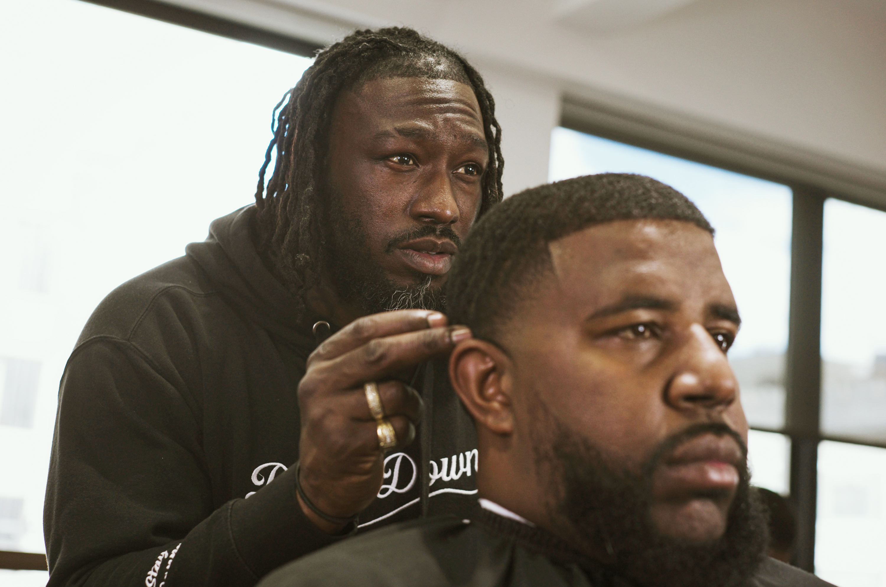 Barber Bryce Ward, left, looks at Adante Pointer’s hair in the mirror during a haircut at Dapper Down Barber Lounge in San Francisco on Tuesday, Feb. 6th, 2024.