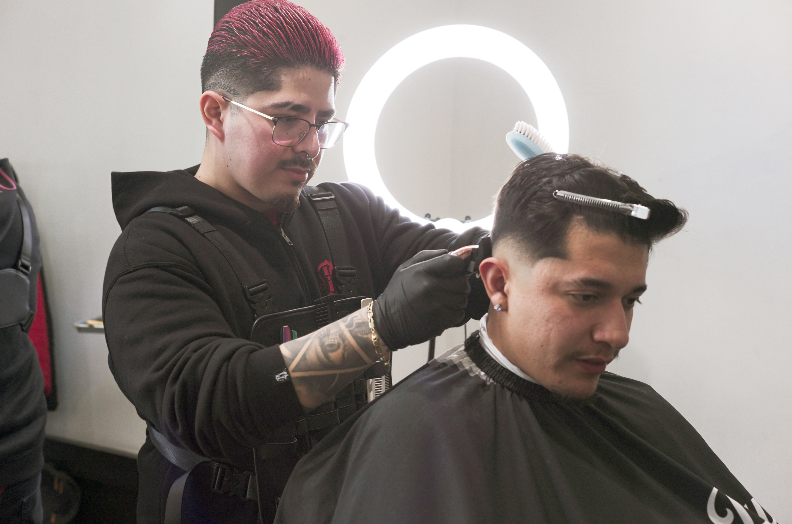 Oakland A’s Team Barber, Fernando Ruiz, left, gives a client a haircut inside Dapper Down Barber Lounge in San Francisco on Tuesday, Feb. 6th, 2024.