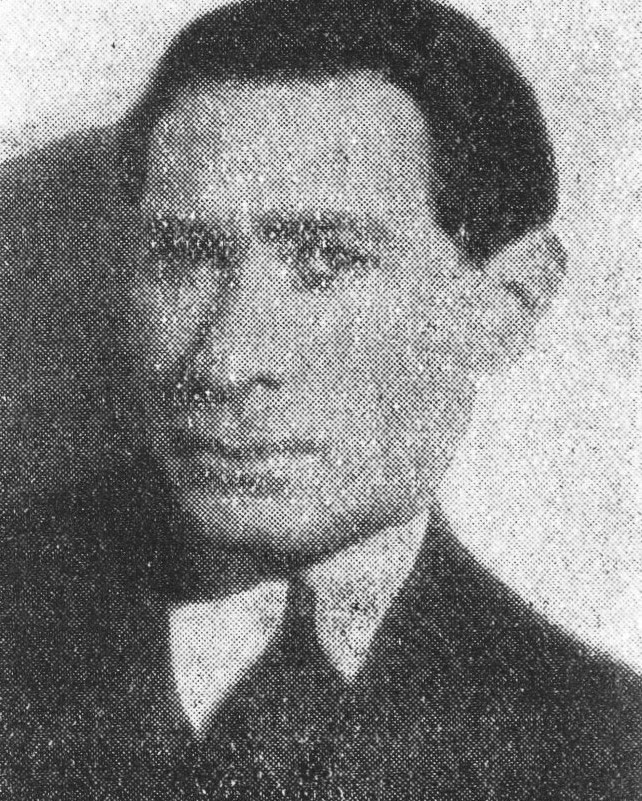 An old, grainy black-and-white photo of a man with short hair, wearing a jacket and tie.