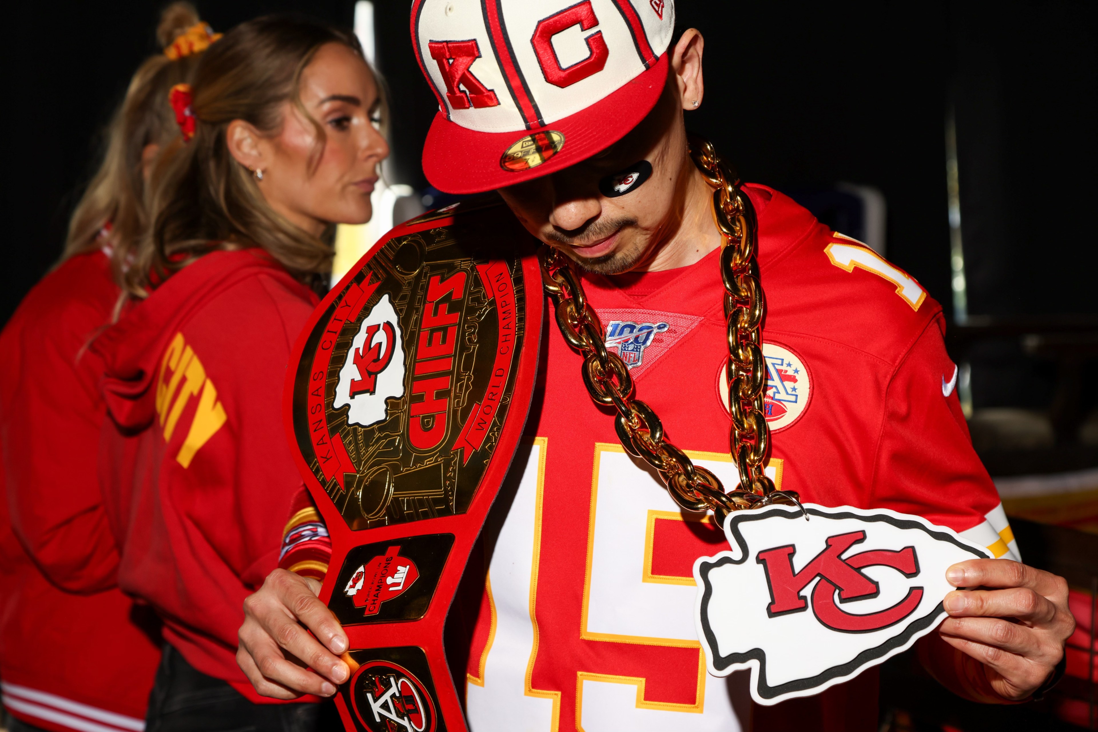 Kansas City Chiefs fan hangs chief belt over shoulder and holds chiefs necklace
