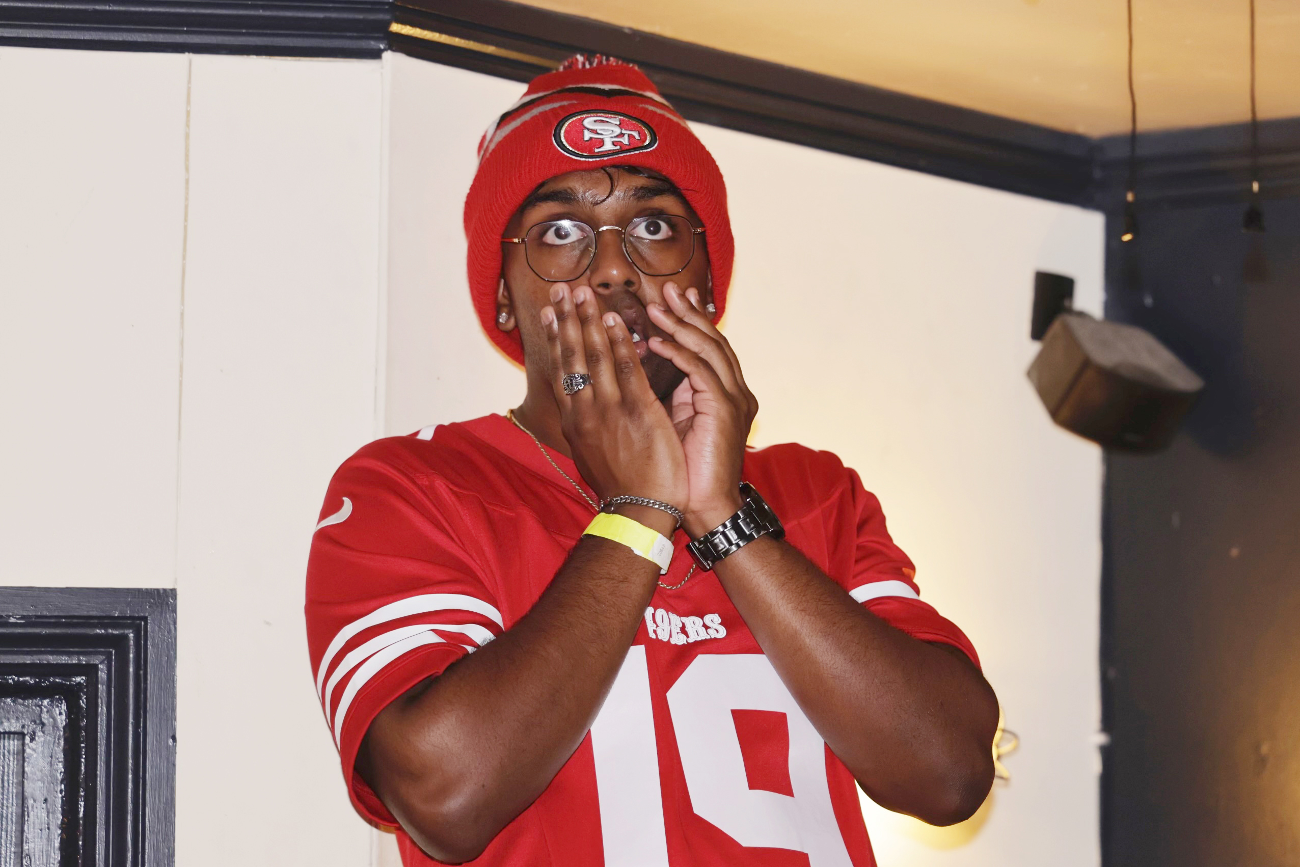 49ers fan holds hands to face while watching football game