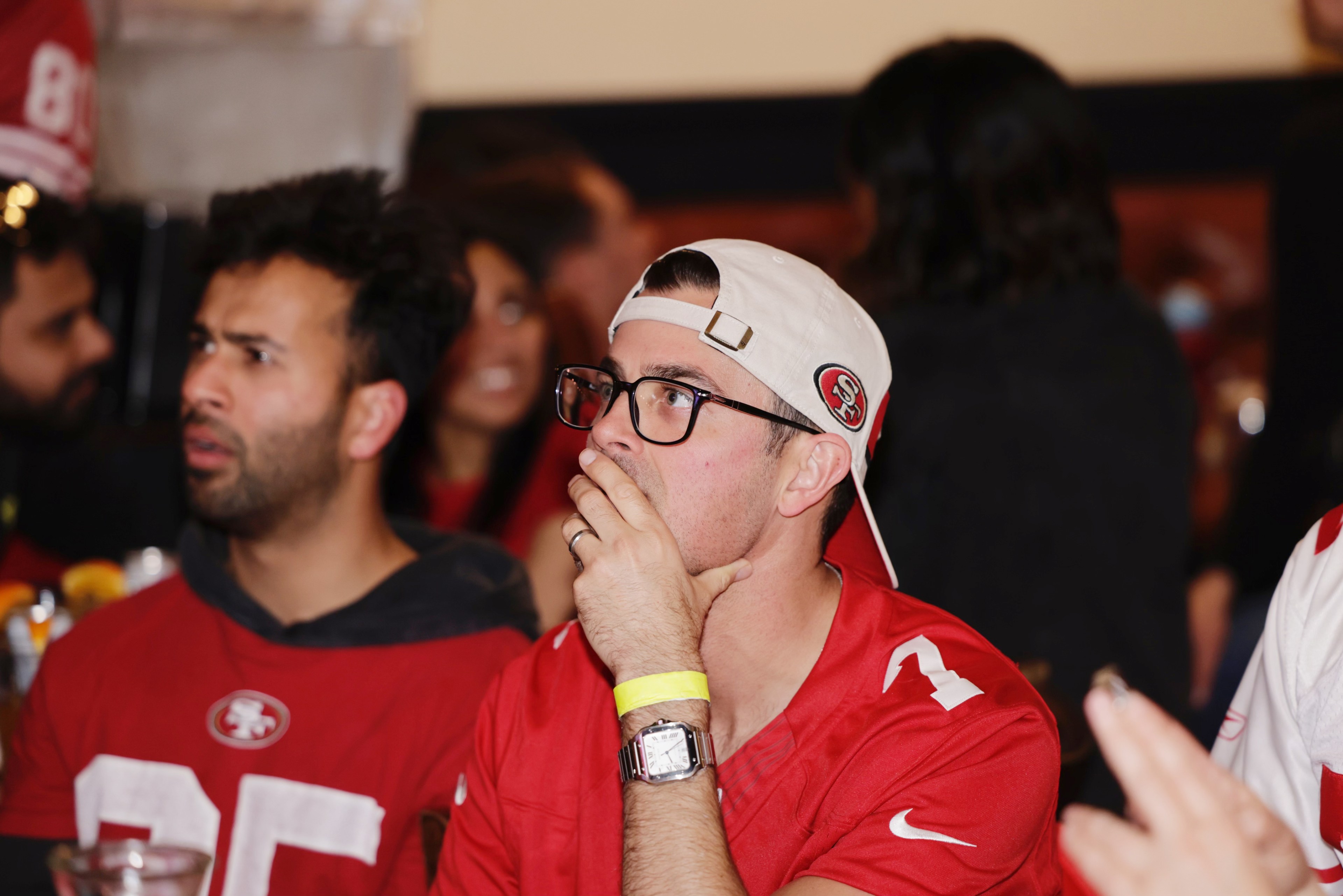 49ers fan holds hand to face while watching game