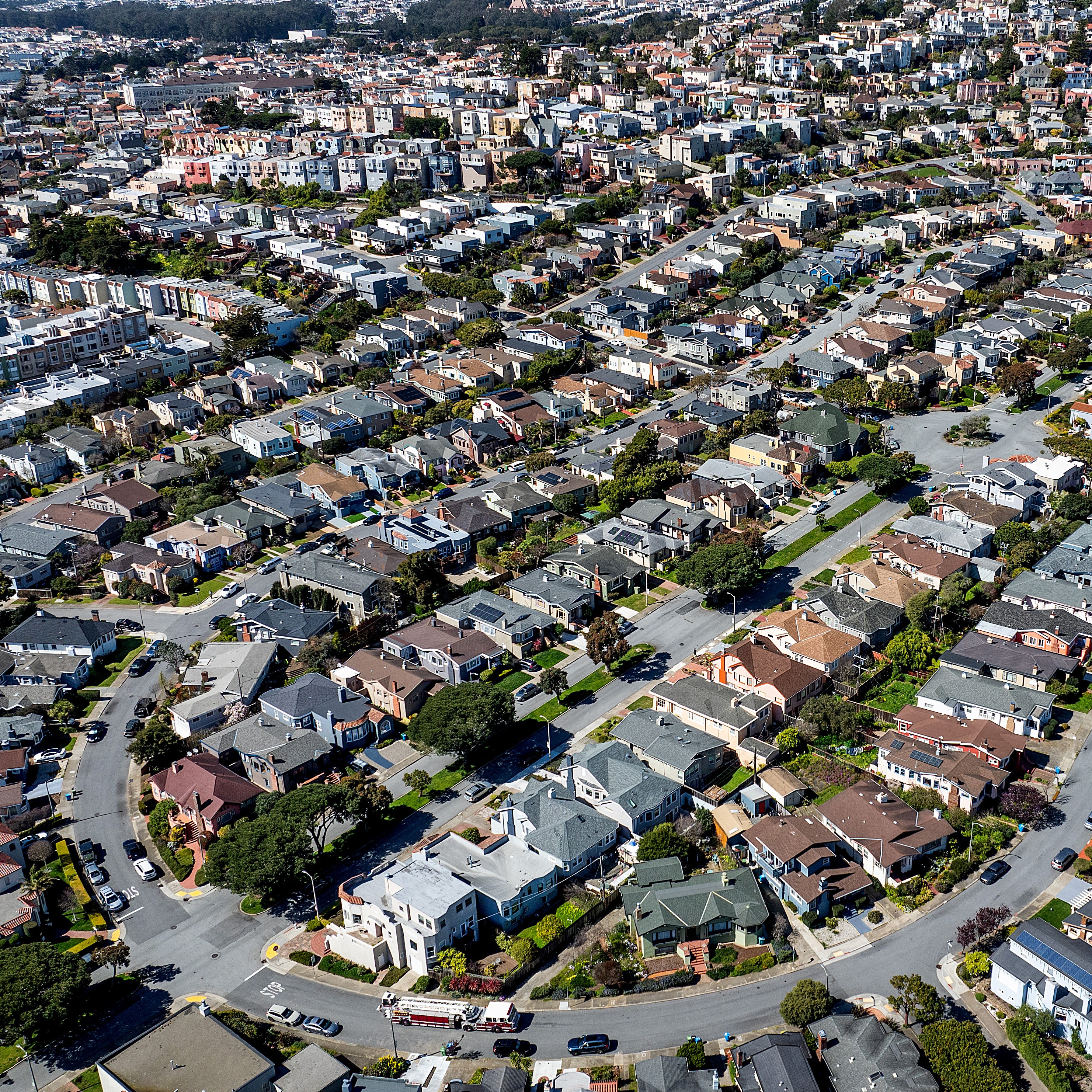 Aerial view of a dense residential area with rows of houses and intersecting streets.
