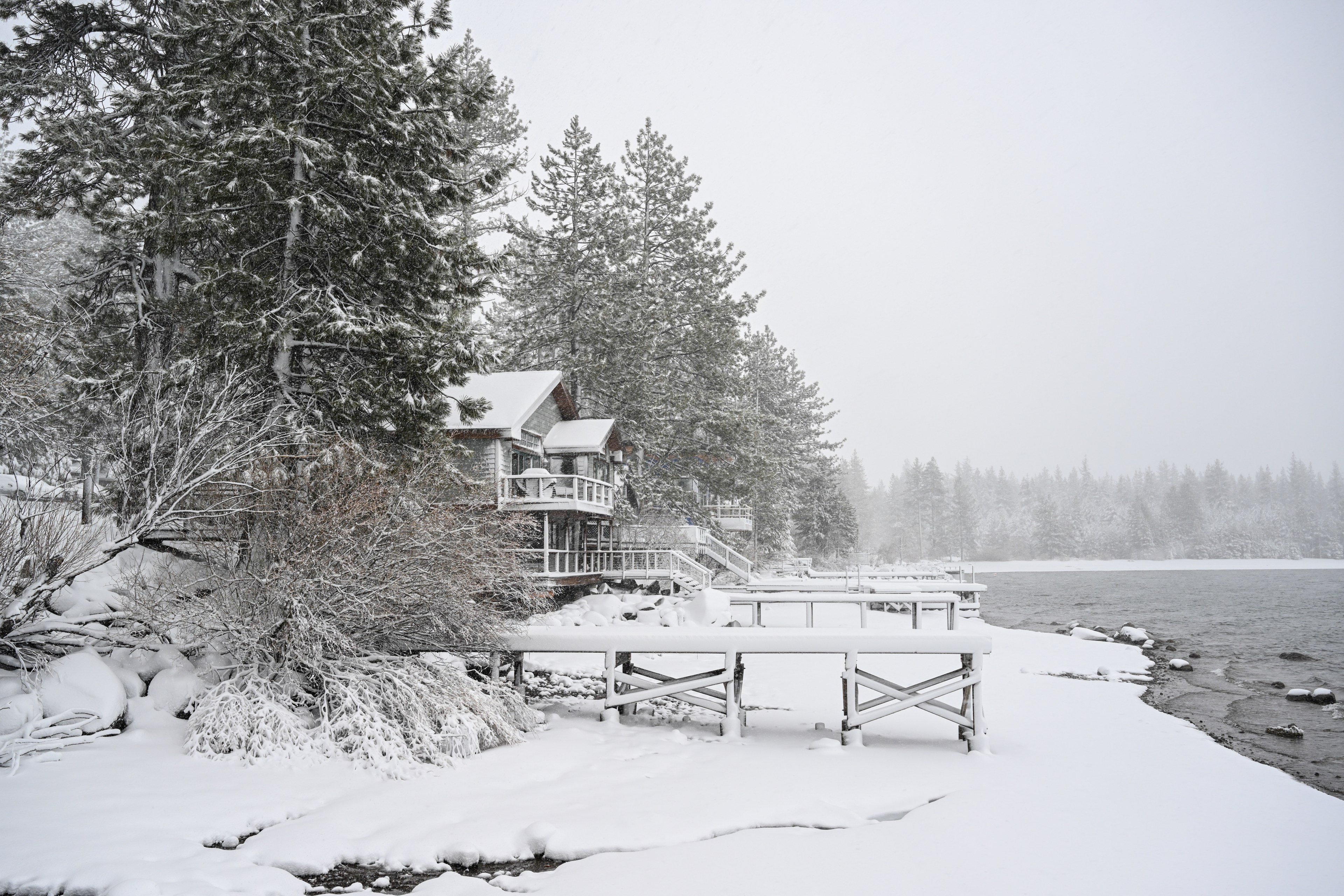 Snow covers piers and homes at the edge of a lake