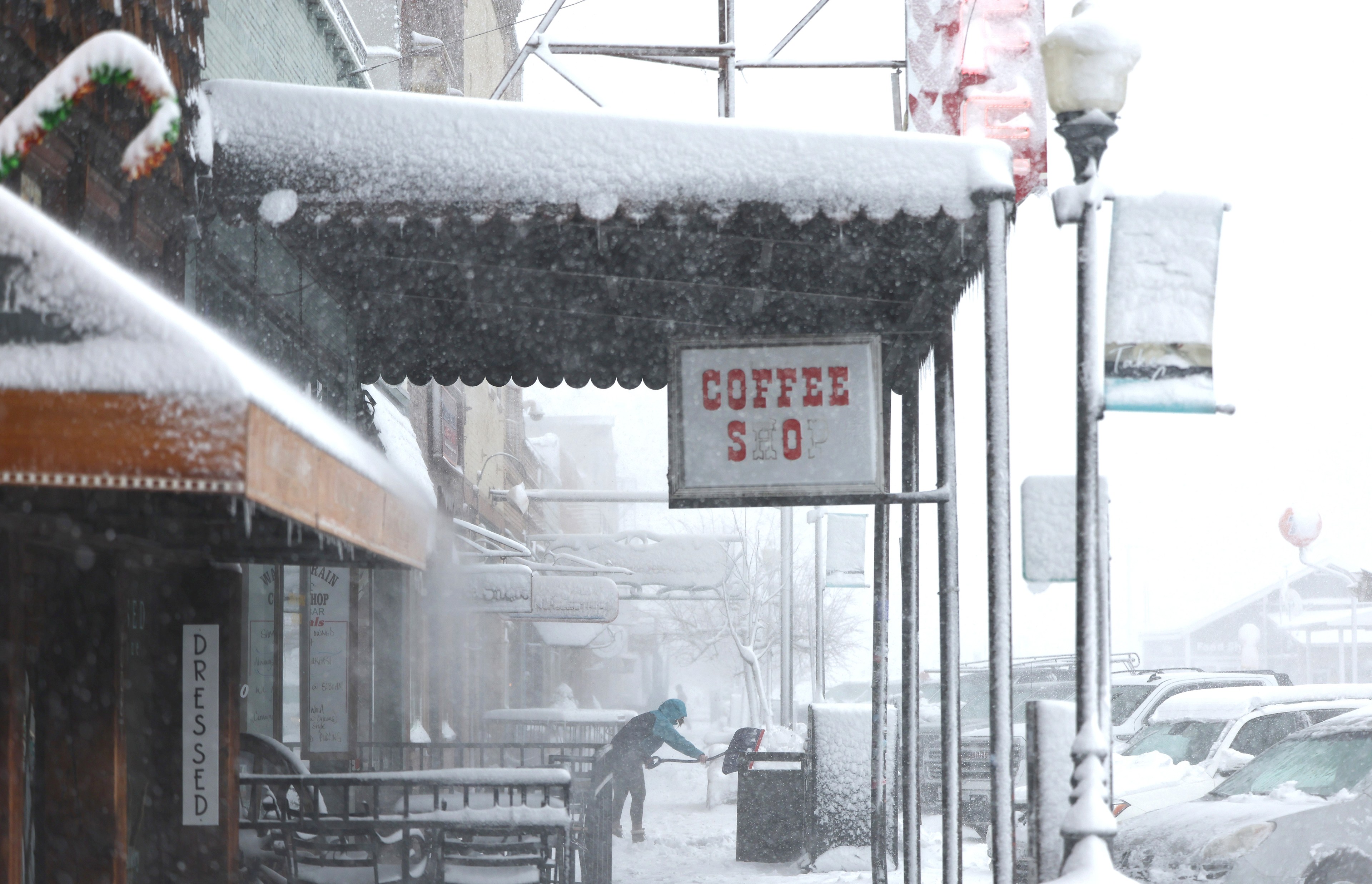 snow covers the awning of a coffee shop