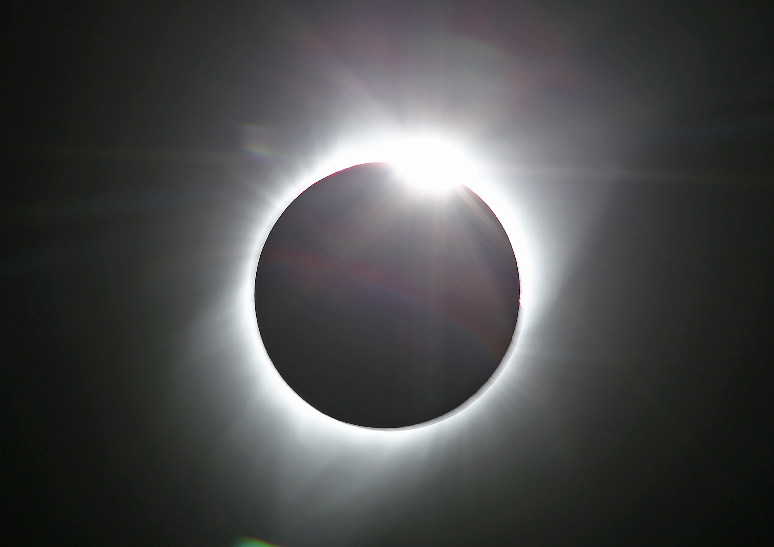 A solar eclipse with the Sun's corona visible around the moon's silhouette.