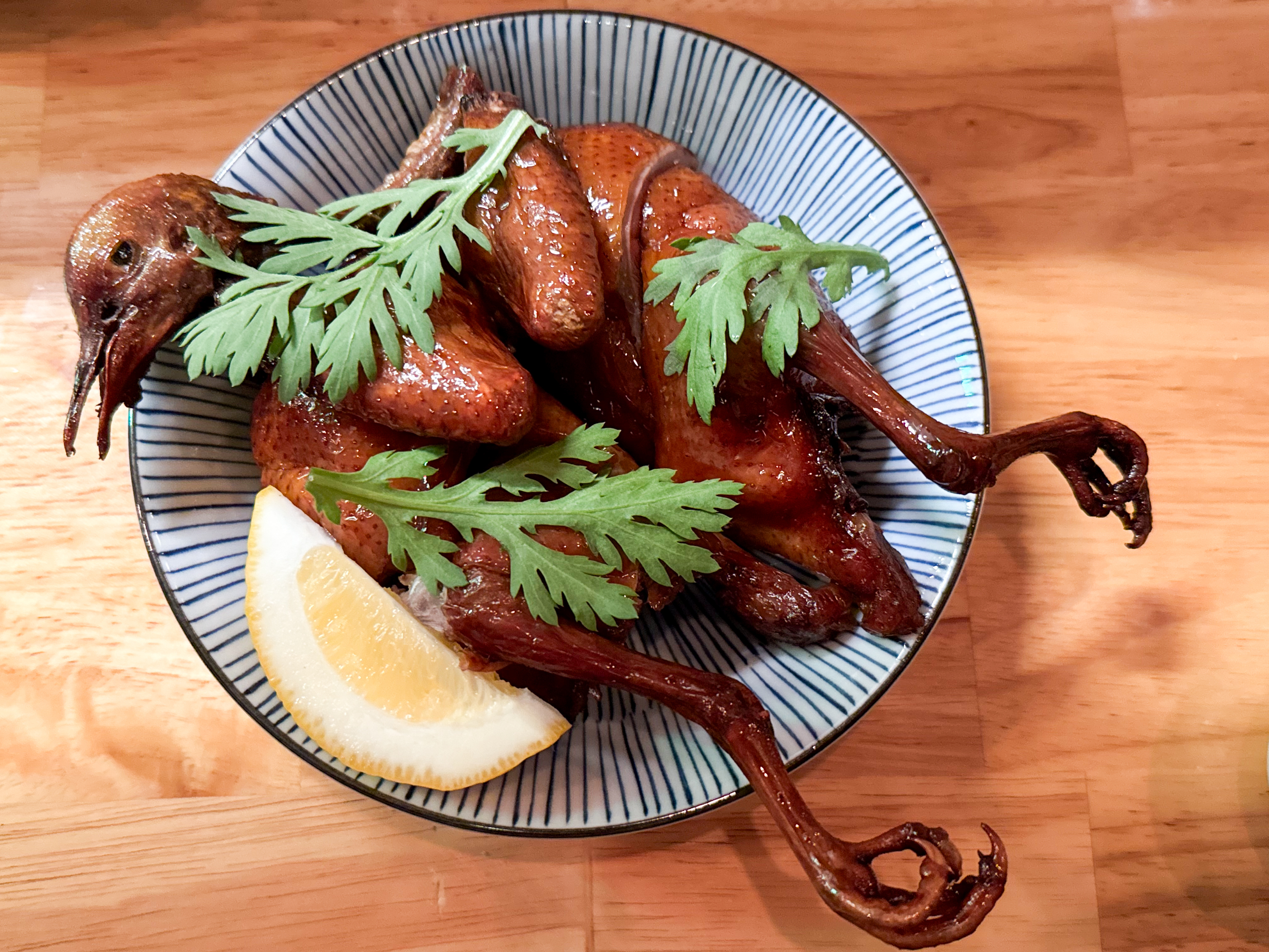 The deep-fried squab at Four Kings is marinated for 10 days, then lightly hickory smoked and deep-fried before serving. The squab is served whole and comes garnished with chrysanthemum greens