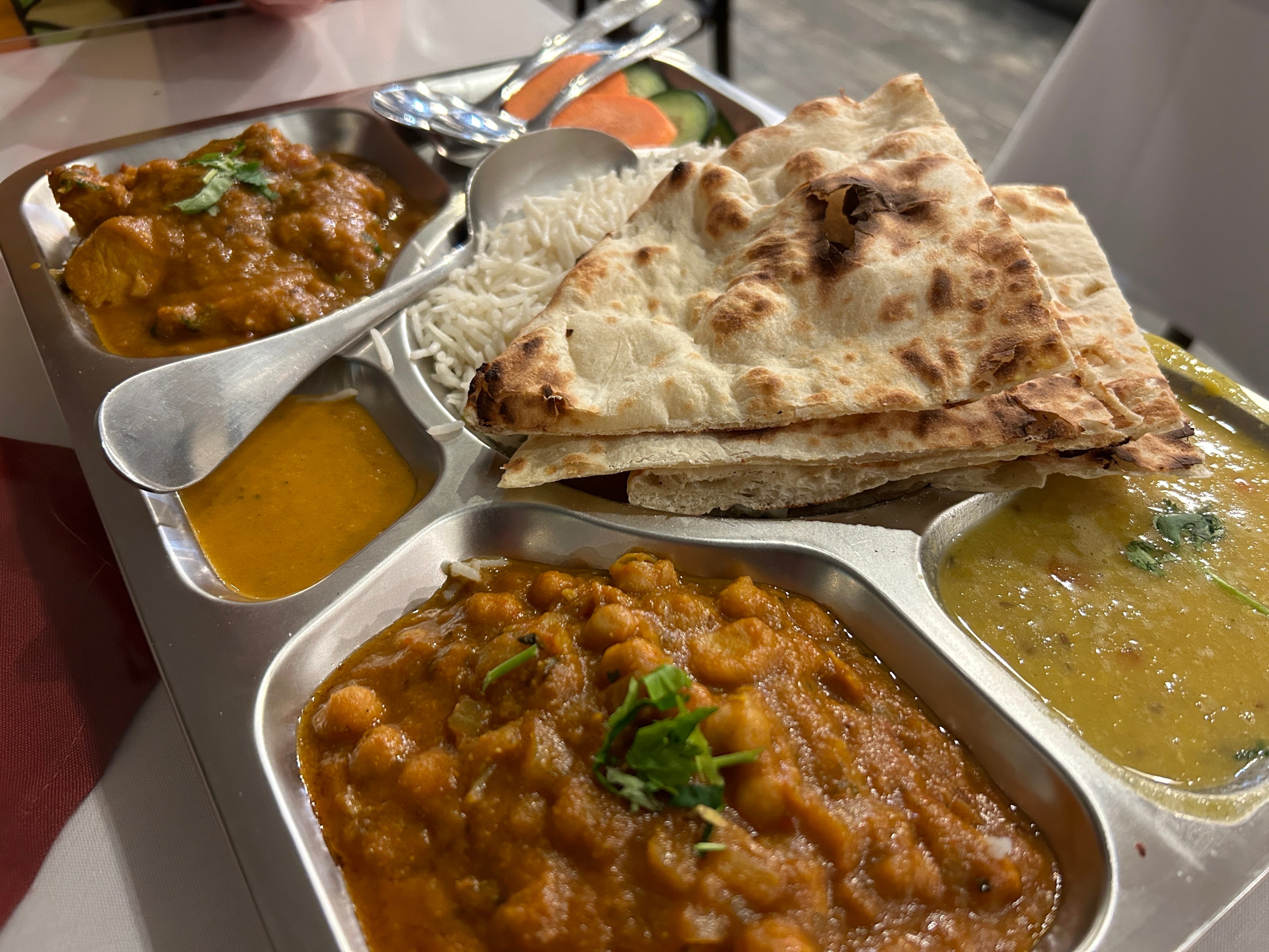a plate of Nepalese food including naan and curry