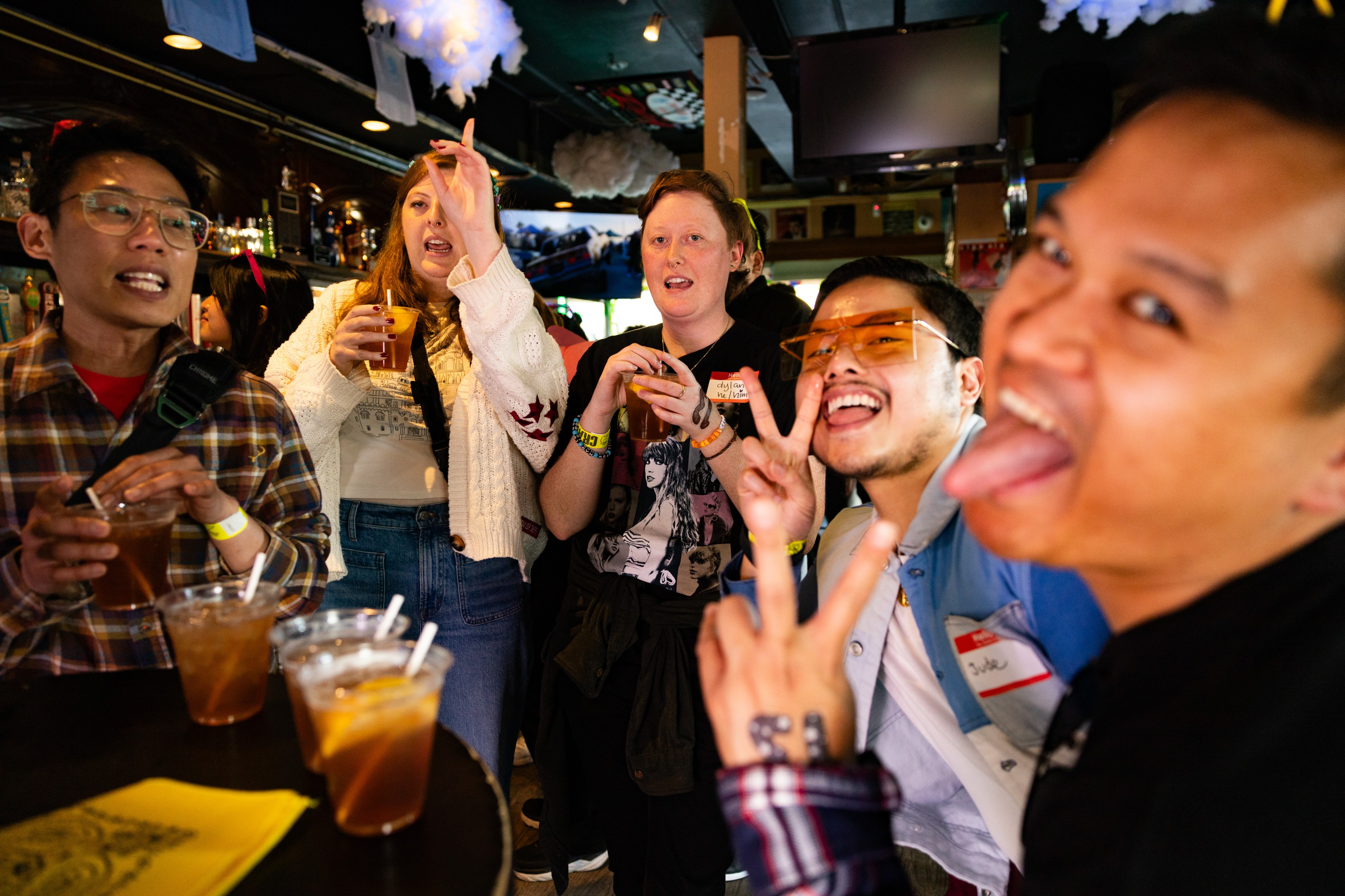 Four women smile and make goof poses at a bar