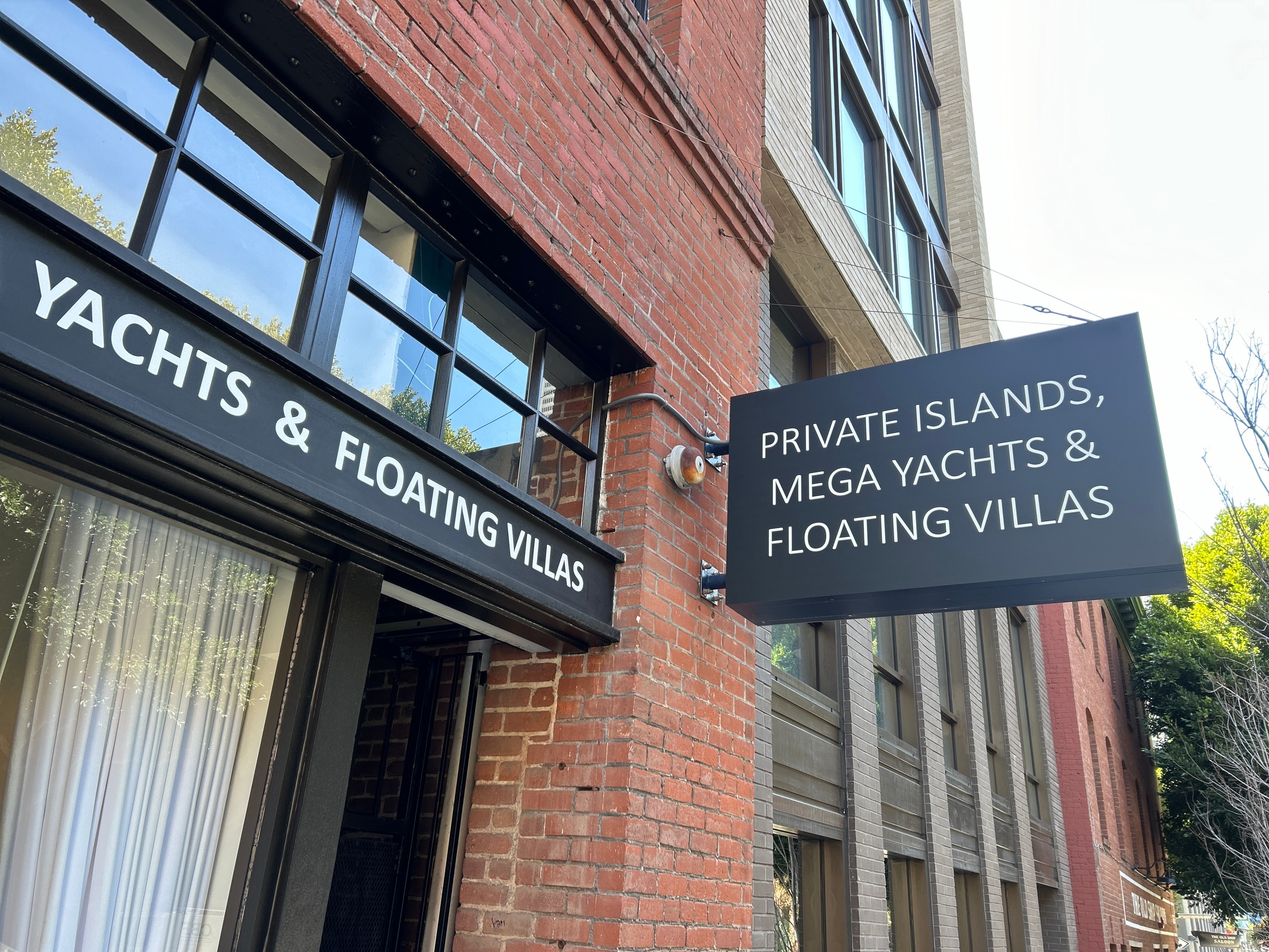 signage on a brick exterior wall advertises private islands and floating villas