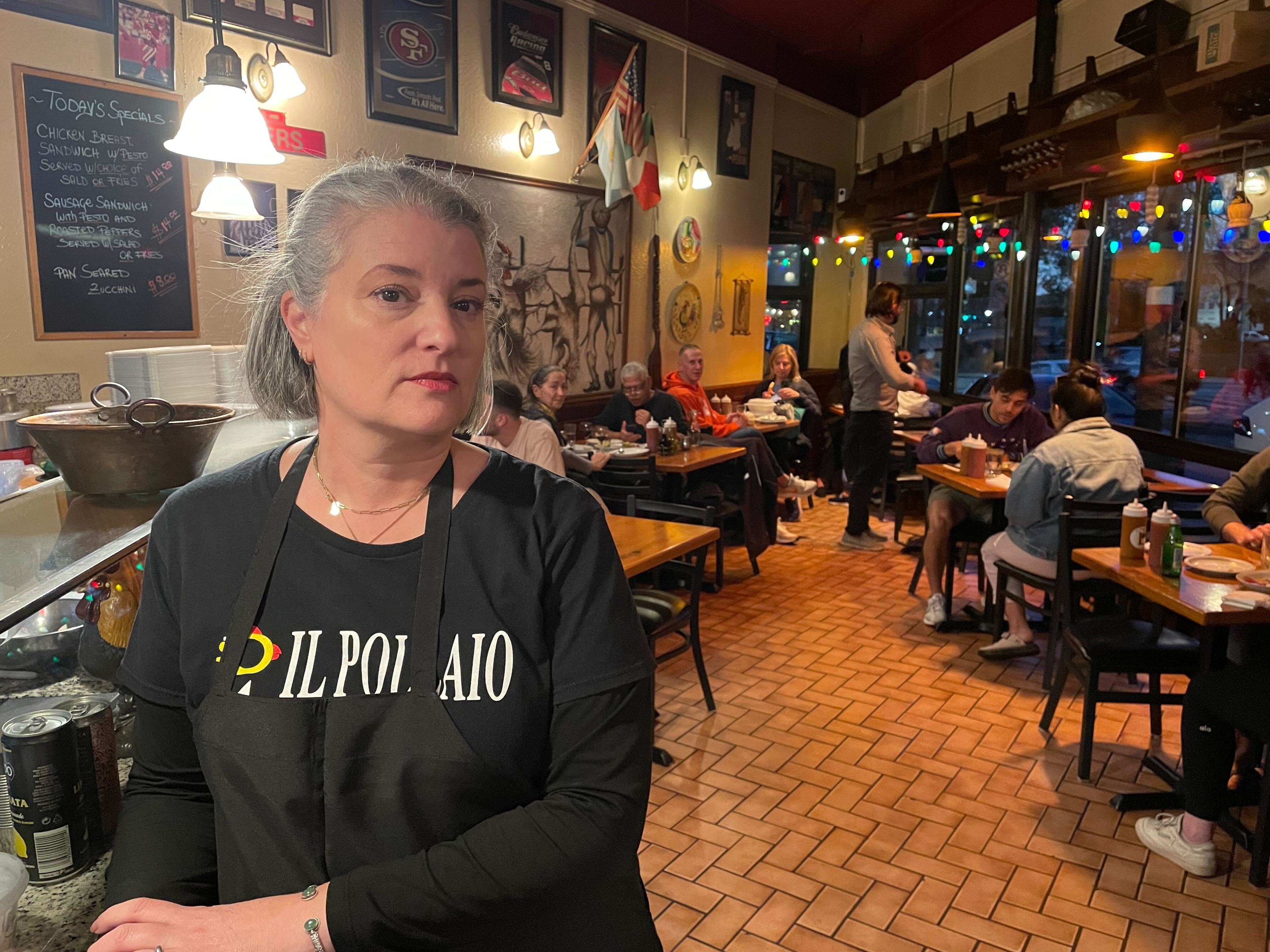 A woman stands inside a restaurant.