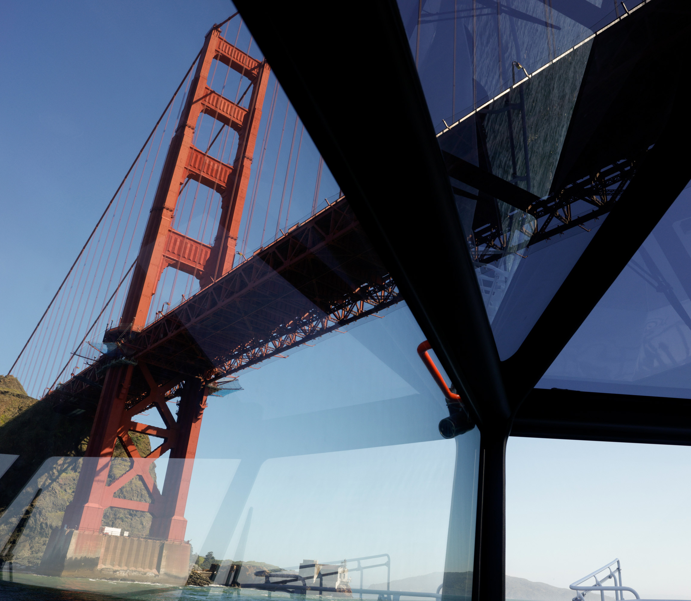 Golden Gate Bridge viewed through geometric windows, with clear skies.