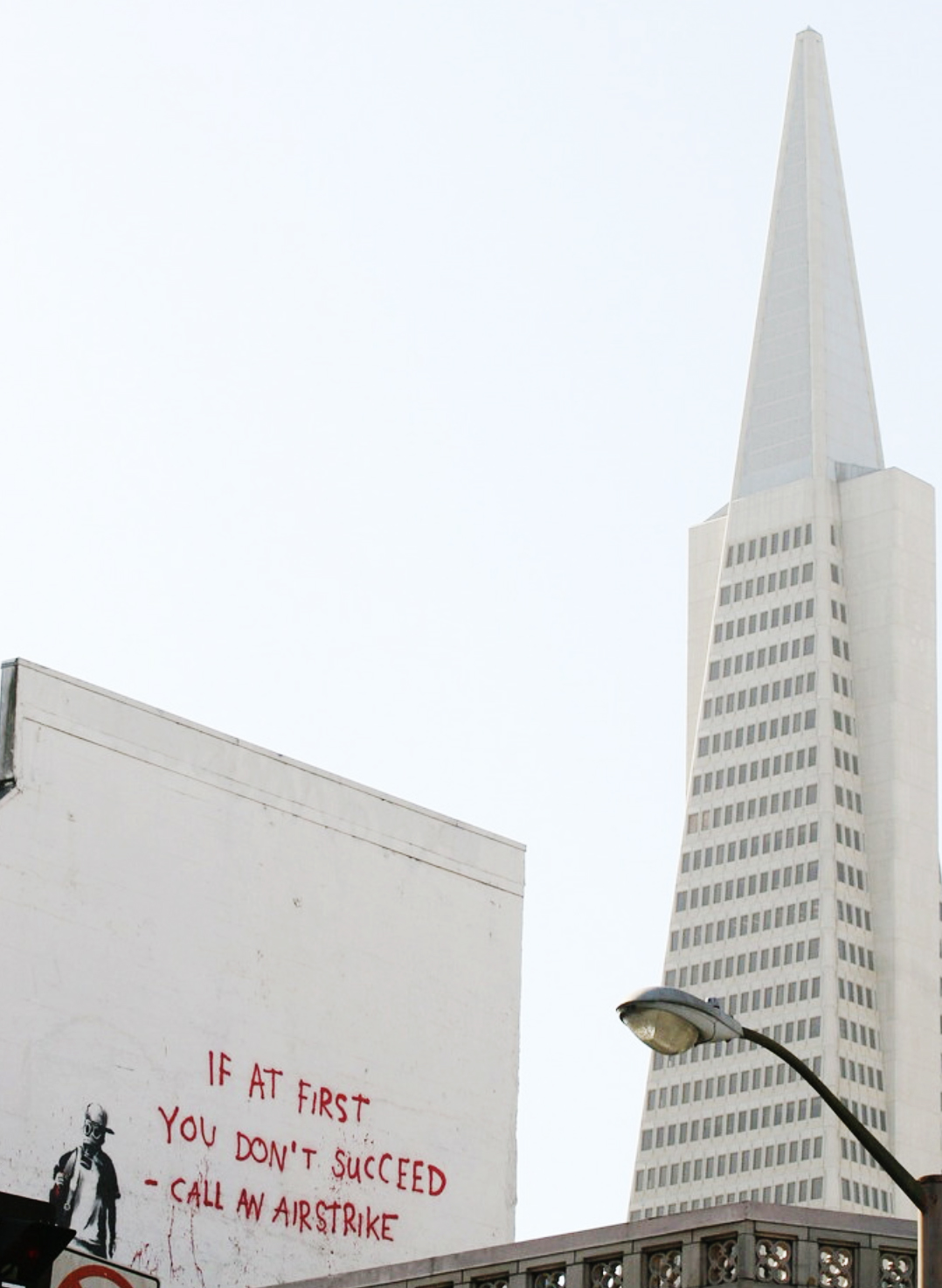 A graffiti painting is seen on a wall with the Transamerica Pyramid in the background.