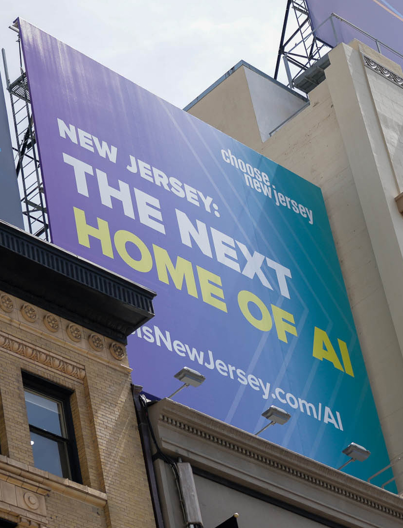 A billboard promoting New Jersey as &quot;THE NEXT HOME OF AI&quot; next to a classic building, with a web address for more info.