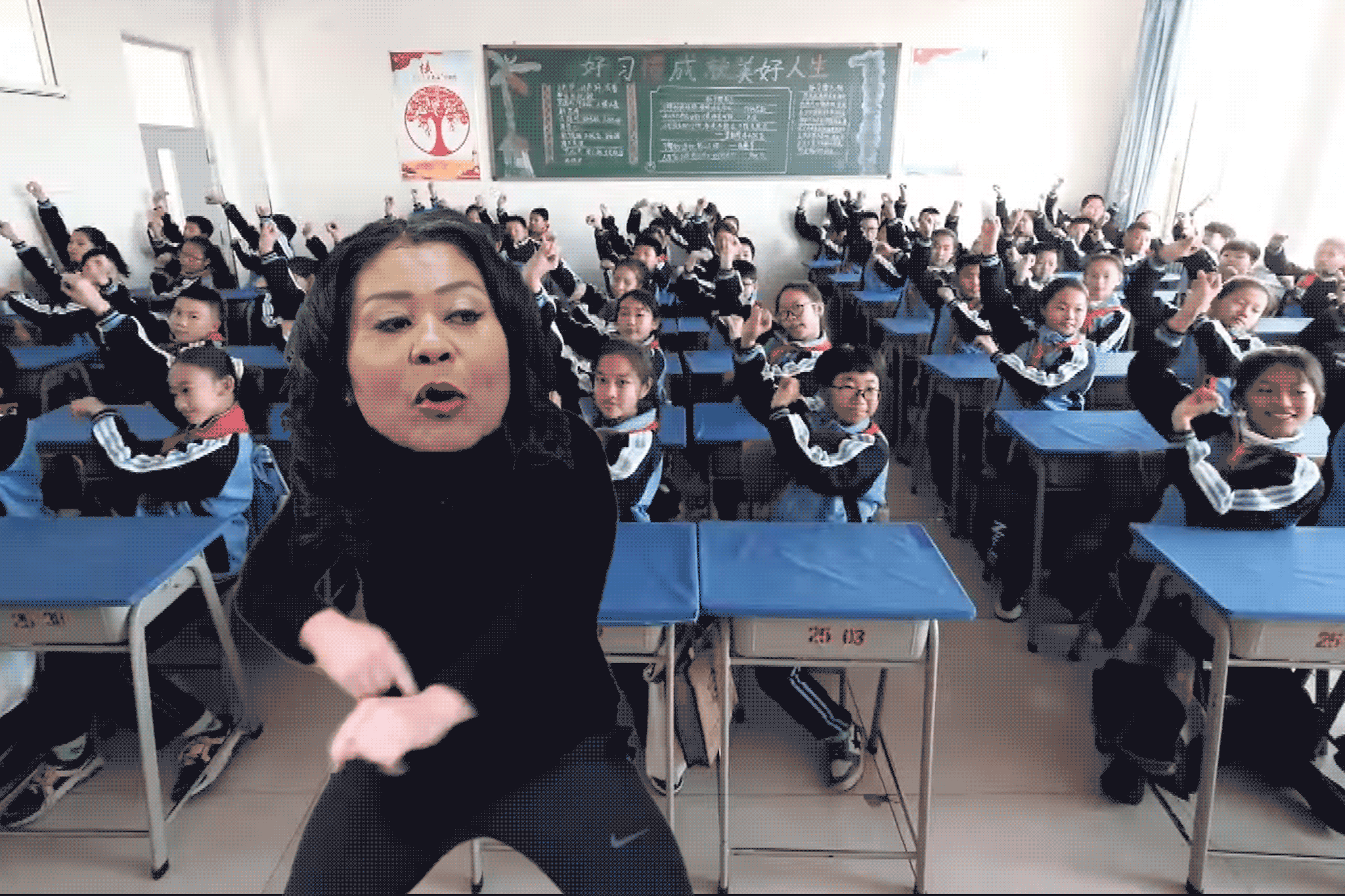 Gif of London Breed dancing along with a classroom of students in China