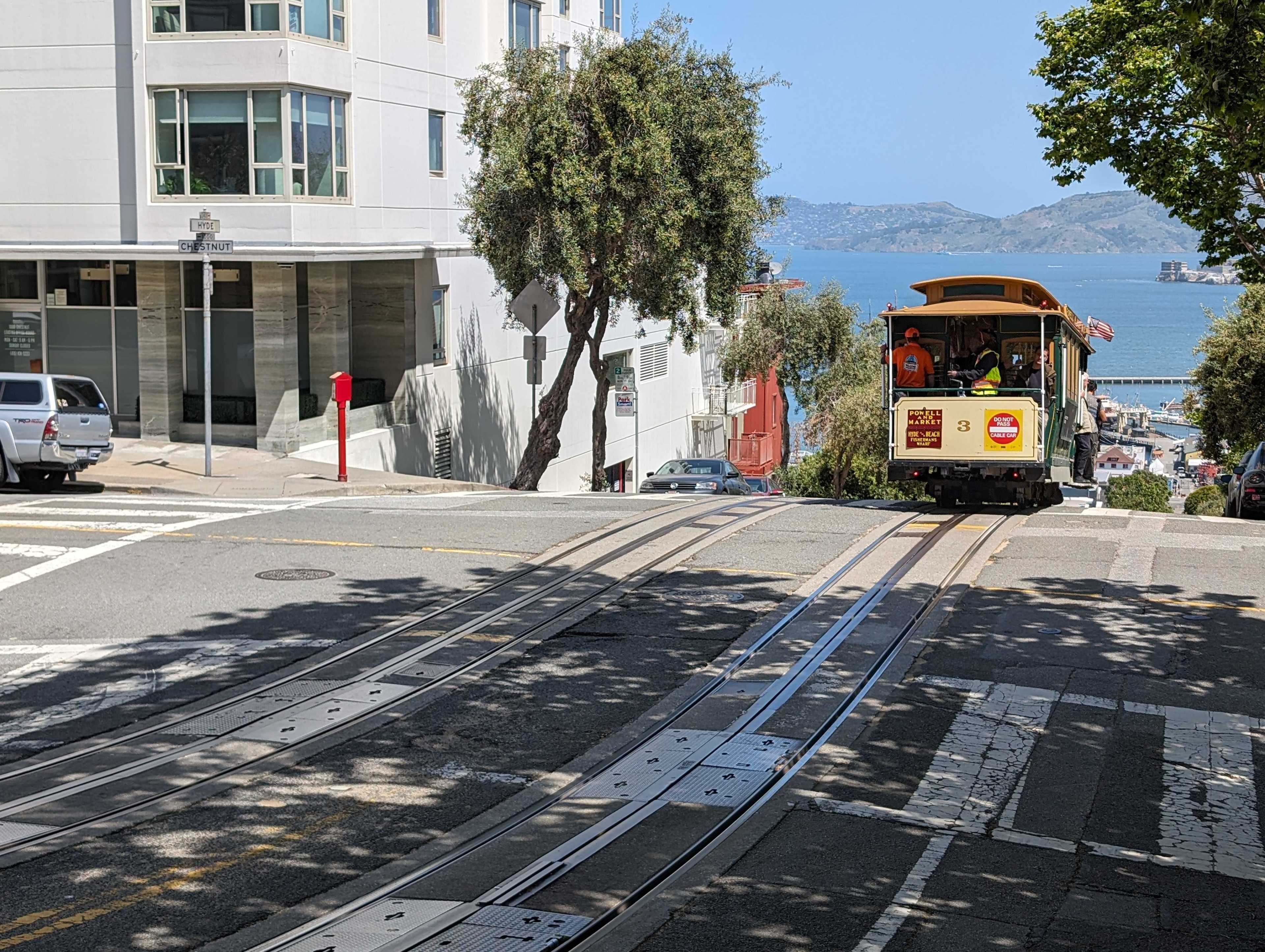 A cable car rides along a hilly street