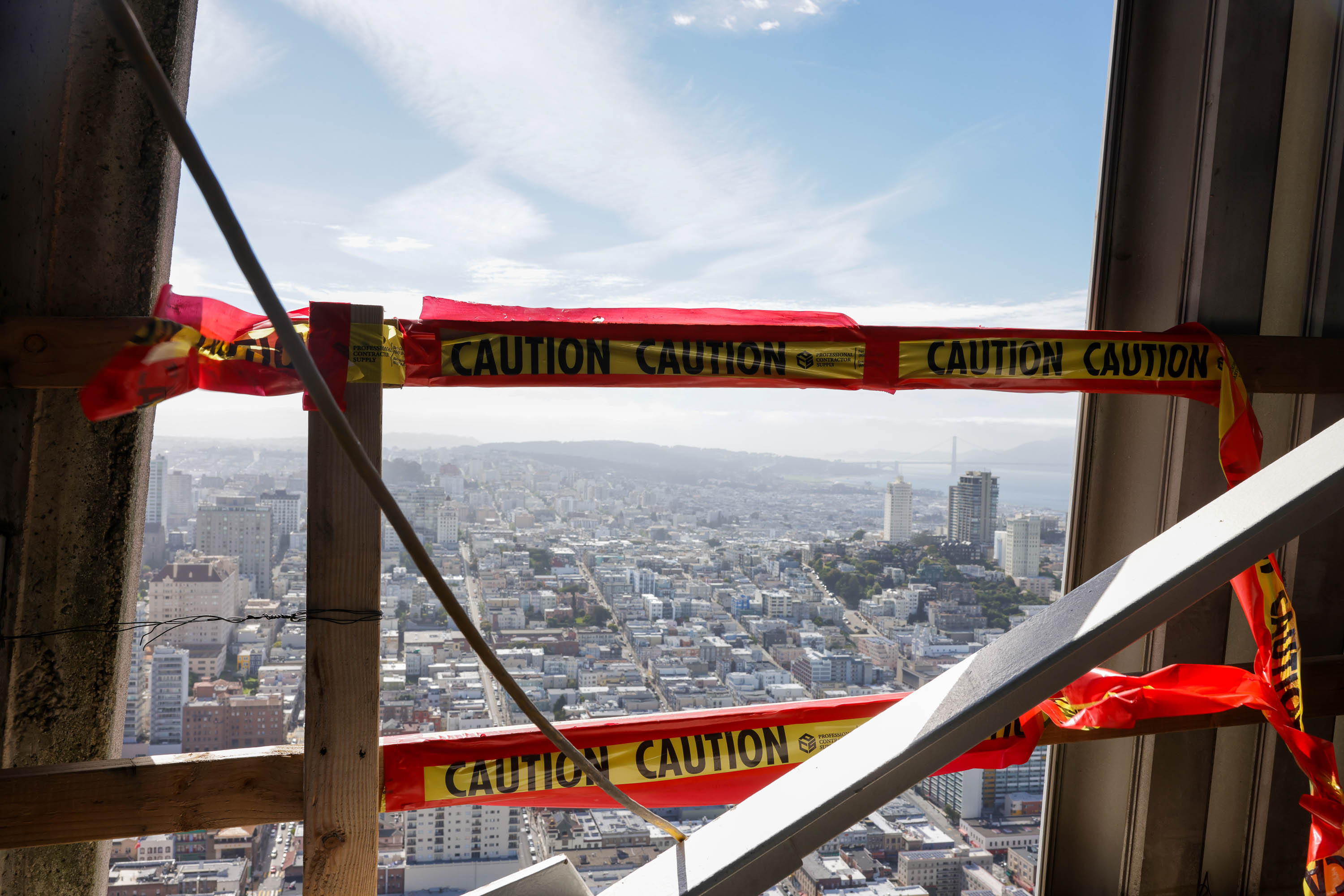 A cityscape viewed through a window with &quot;CAUTION&quot; tape across the foreground.