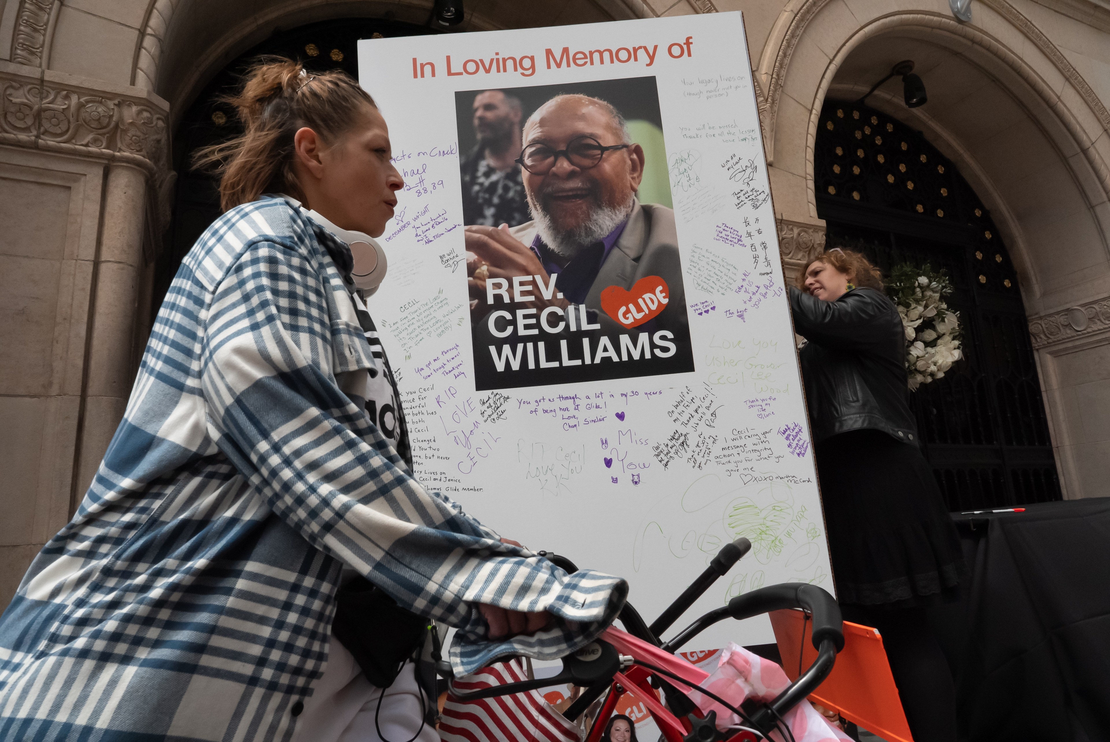 A woman signs a large memory card during a Celebration of the Life for co-founder Reverend Cecil Williams at the Glide Memorial Church Sanctuary in San Francisco on Sunday, May 12, 2024.