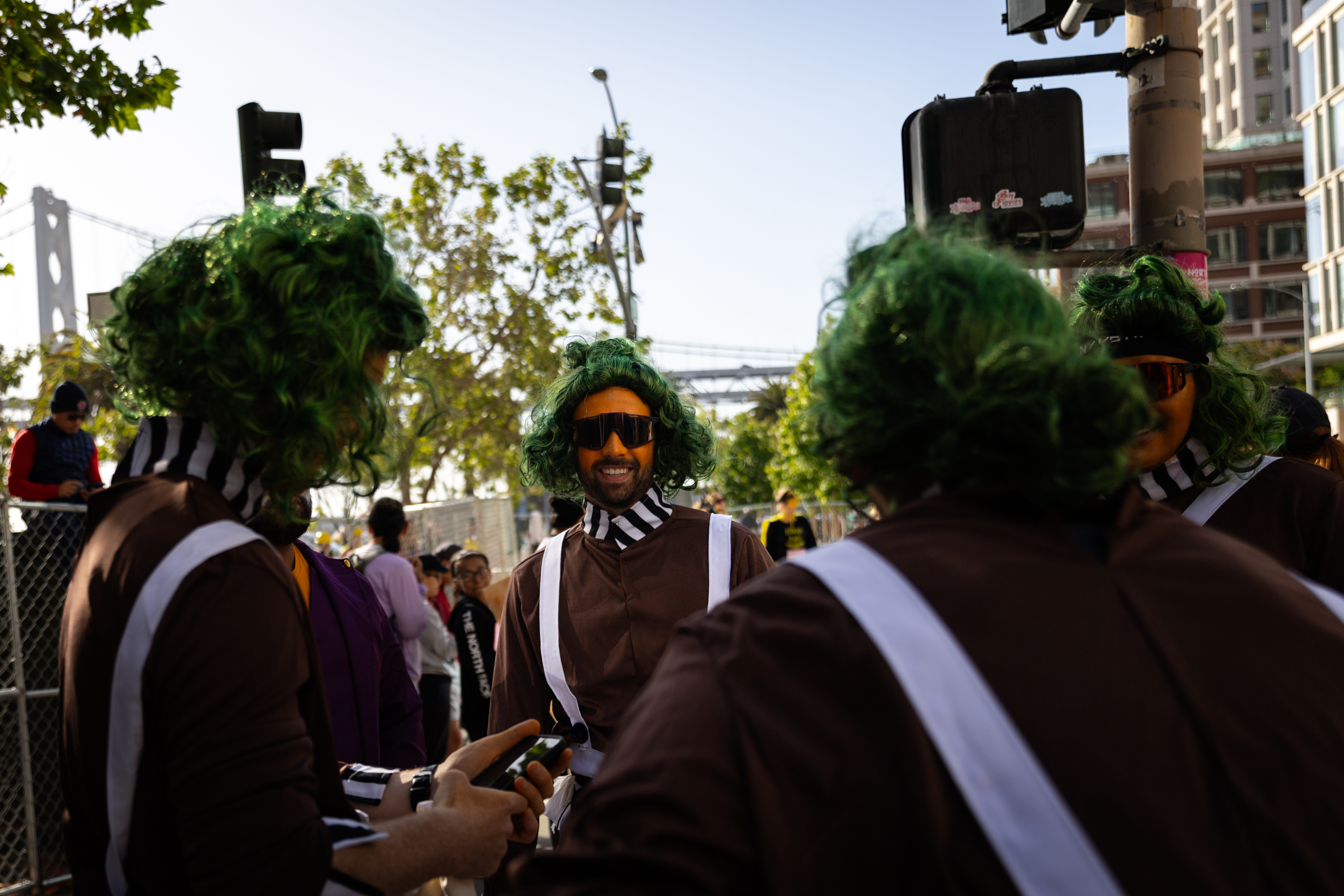 Brown costumed runners wearing long green wigs and sunglasses get ready to run a foot race