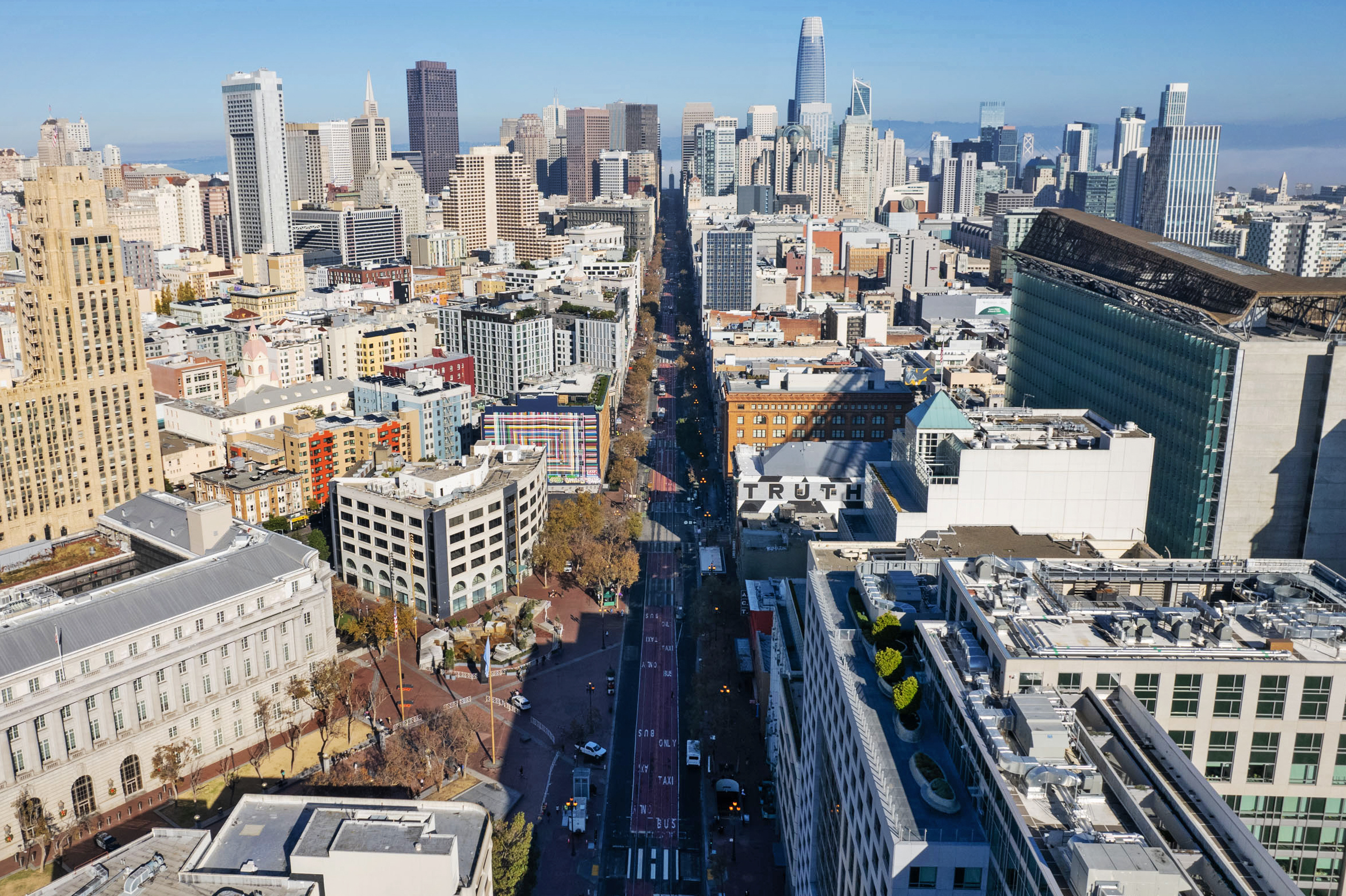 Aerial view of a dense urban cityscape with a mix of high-rise buildings and a clear sky.