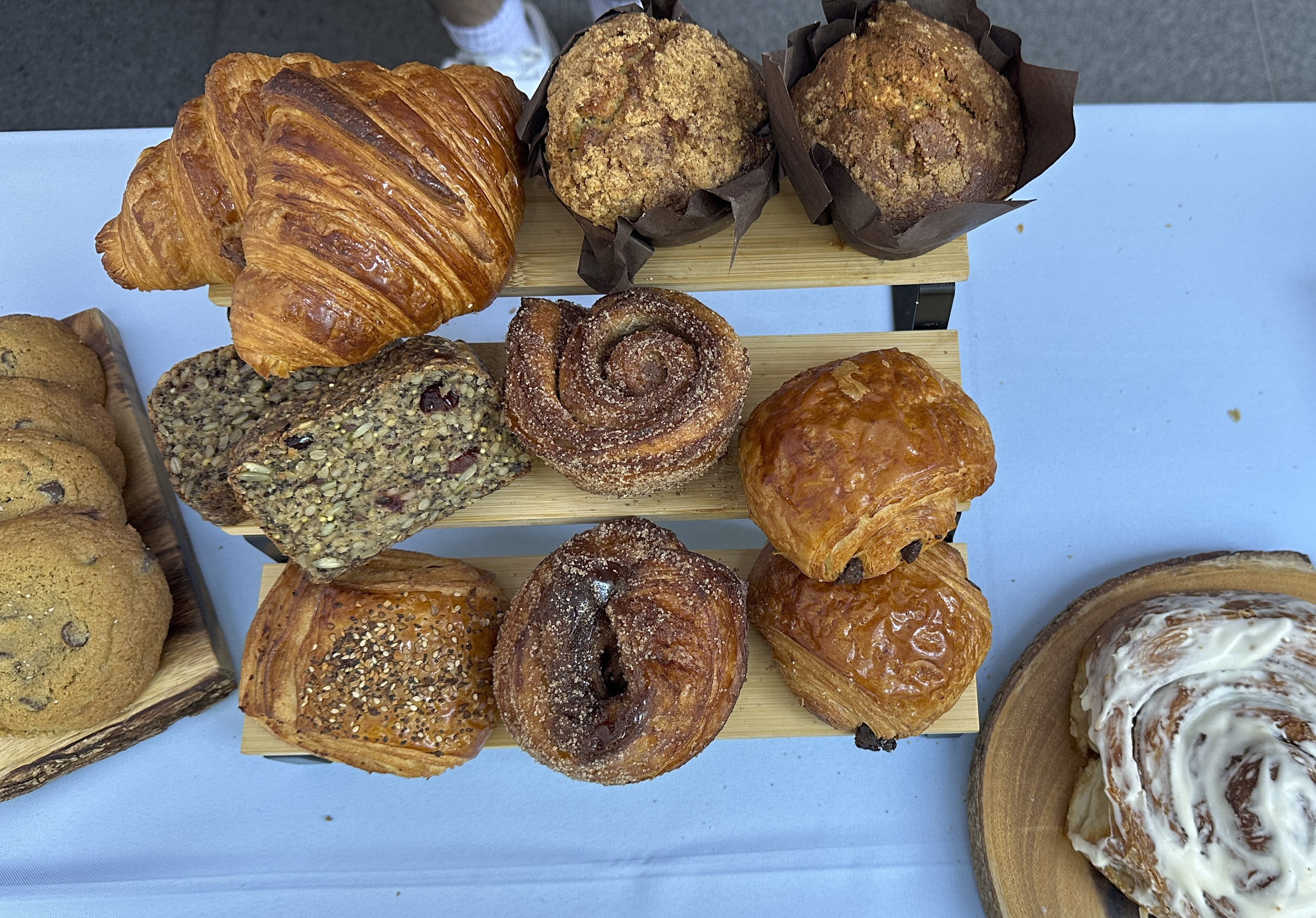 An assortment of pastries are set out on a blue table cloth. 