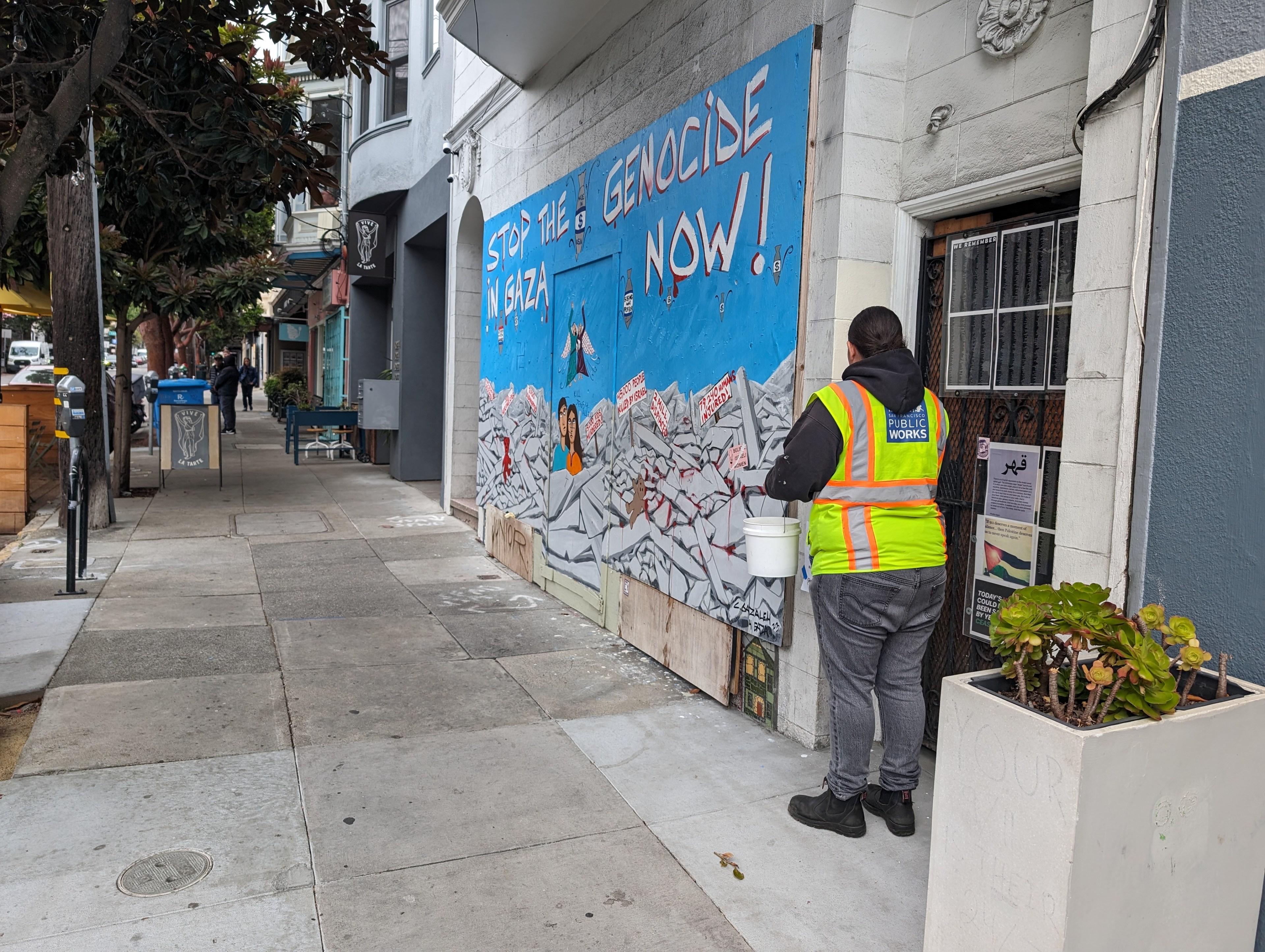 A city public works employee painted over a wall Wednesday morning beside a mural persistently vandalized by hate symbols and religiously charged hate speech outside a 24th Street building in Noe Valley.