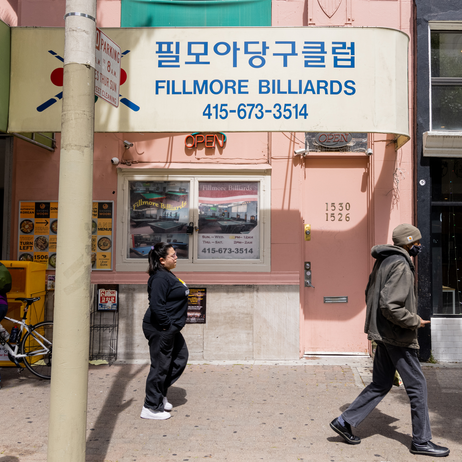 The image depicts two people walking past a pink building with a sign in both Korean and English for &quot;Fillmore Billiards,&quot; located at 1530-1526.